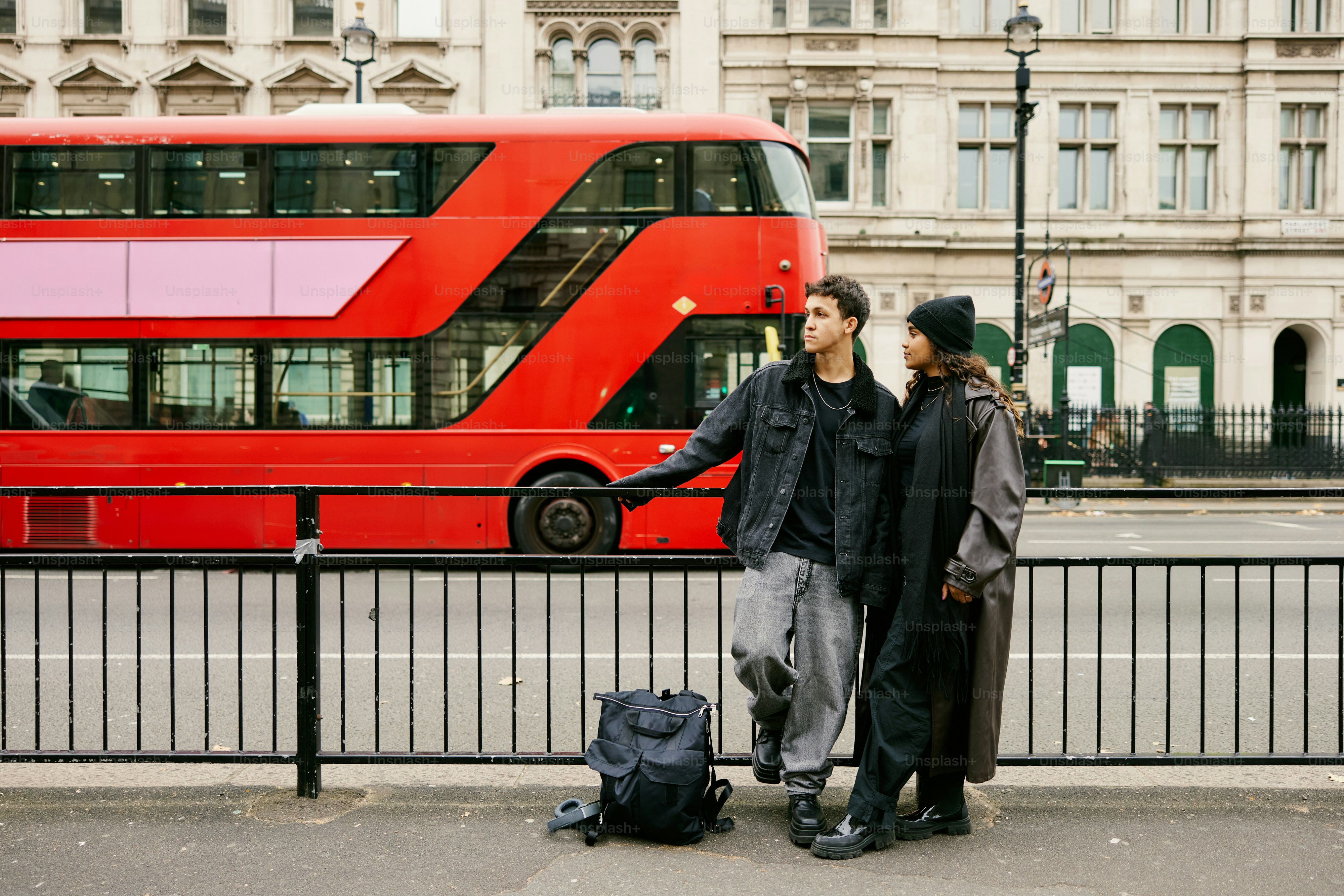Ein Mann und eine Frau stehen vor einem roten Doppeldeckerbus
