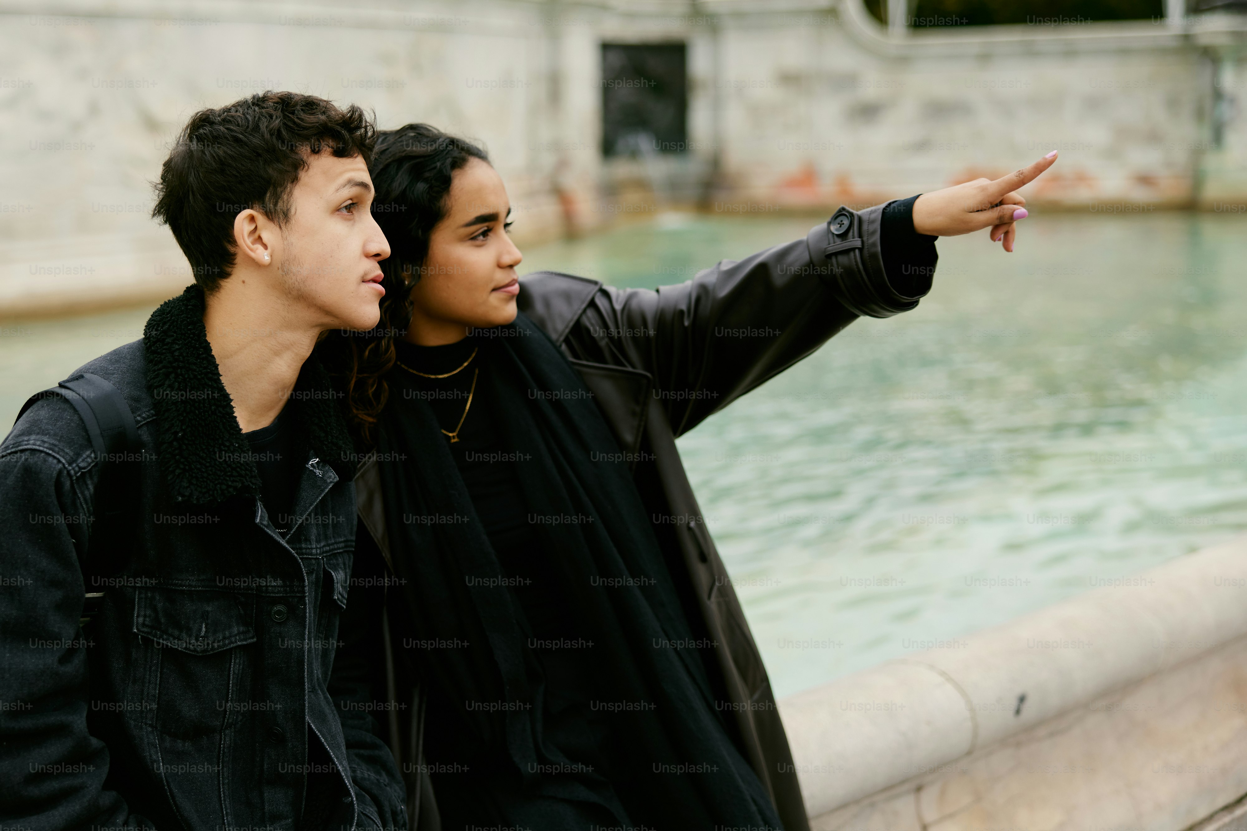 A man and a woman standing next to a fountain