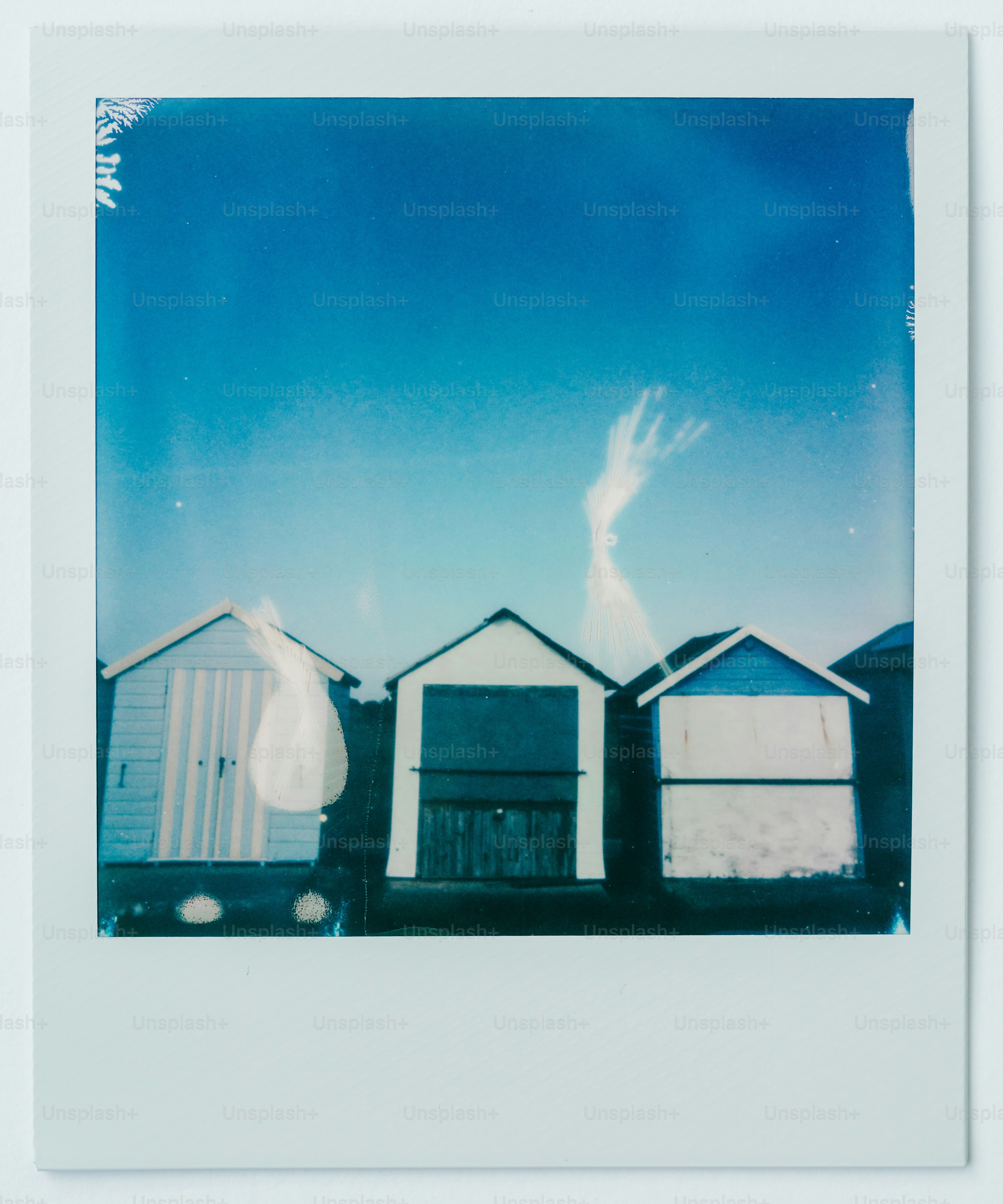 A polaroid photograph of a row of beach huts