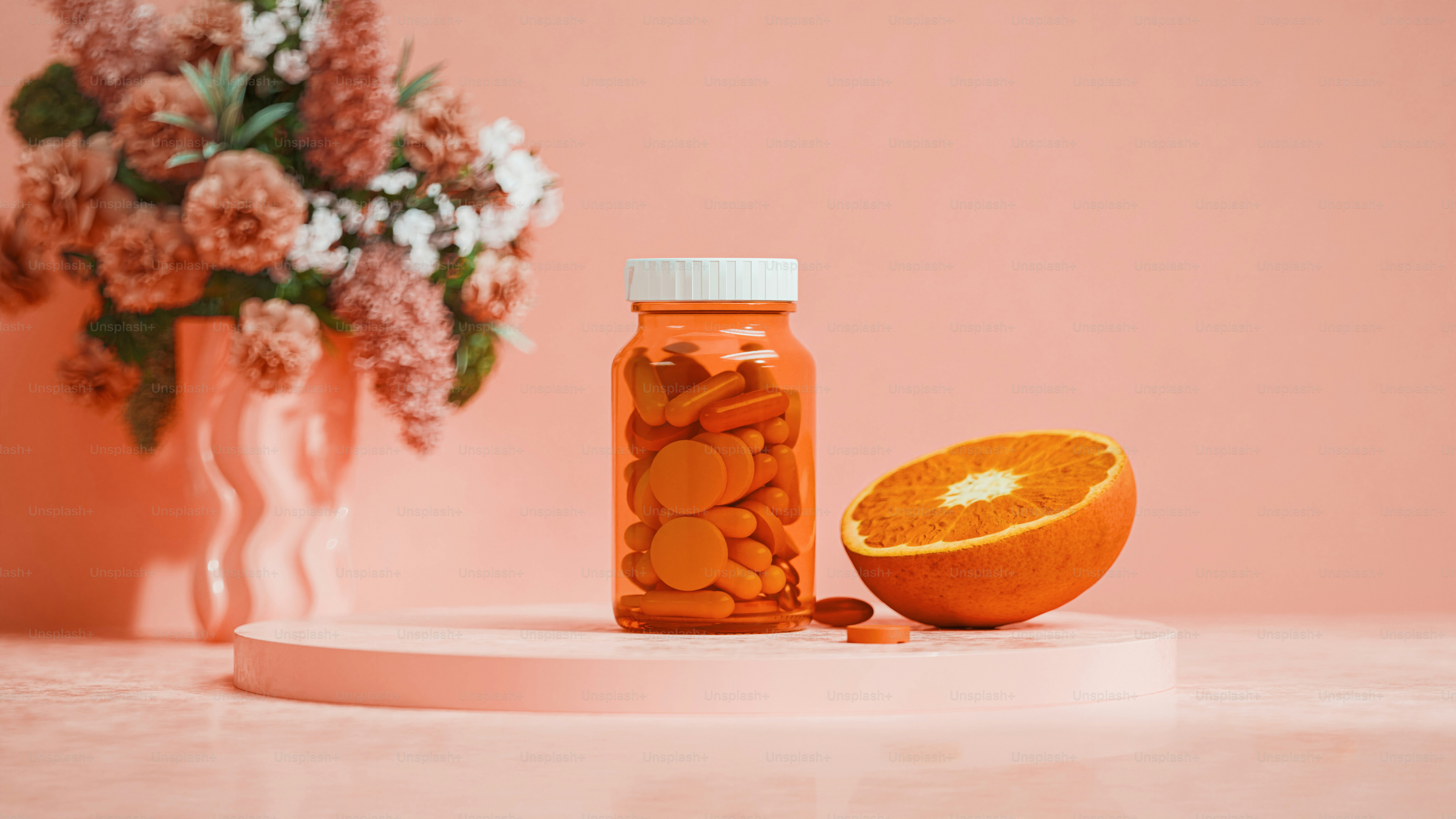 Una naranja sentada sobre una mesa junto a un jarrón de flores