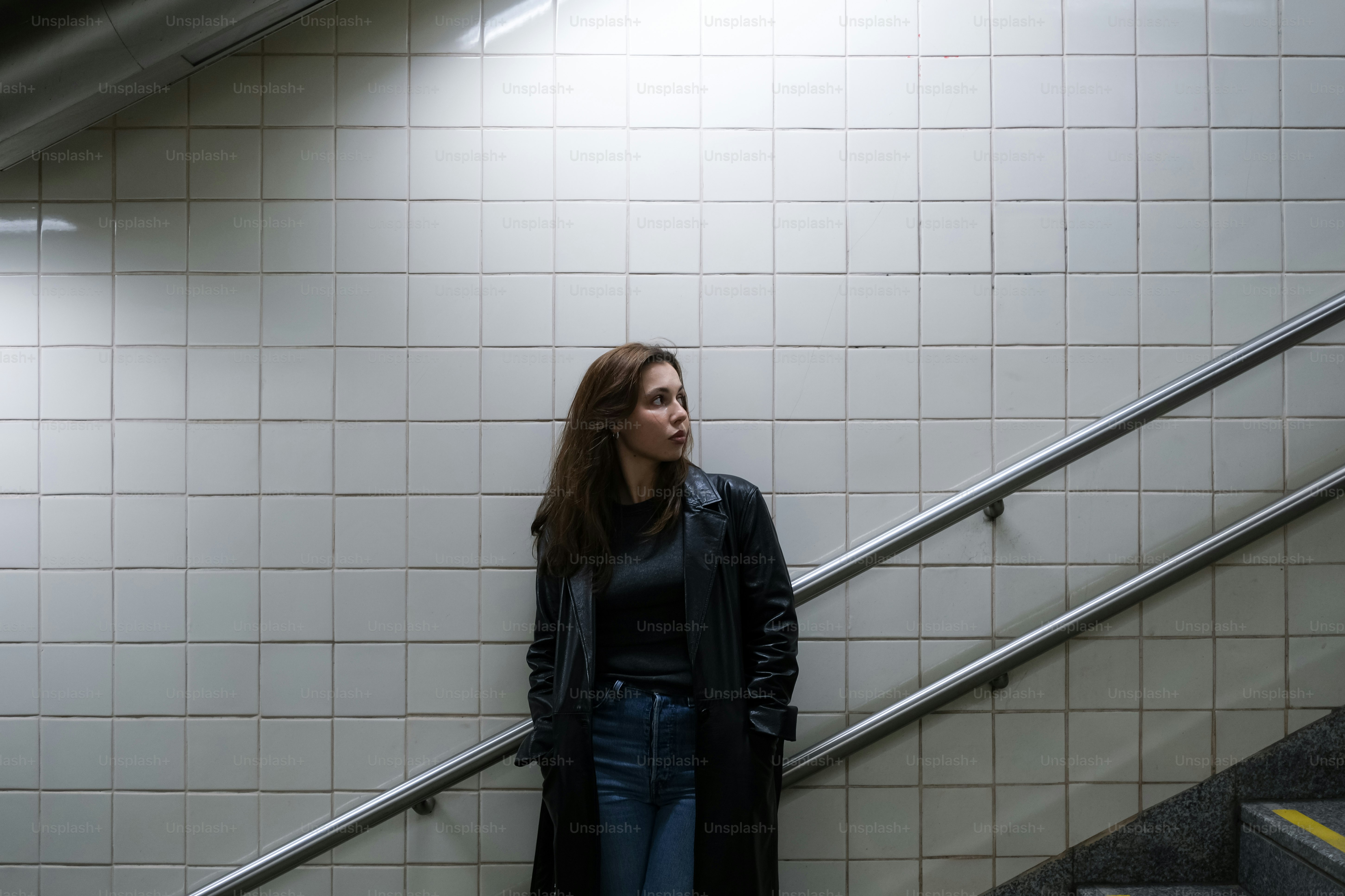 A woman standing at the bottom of an escalator