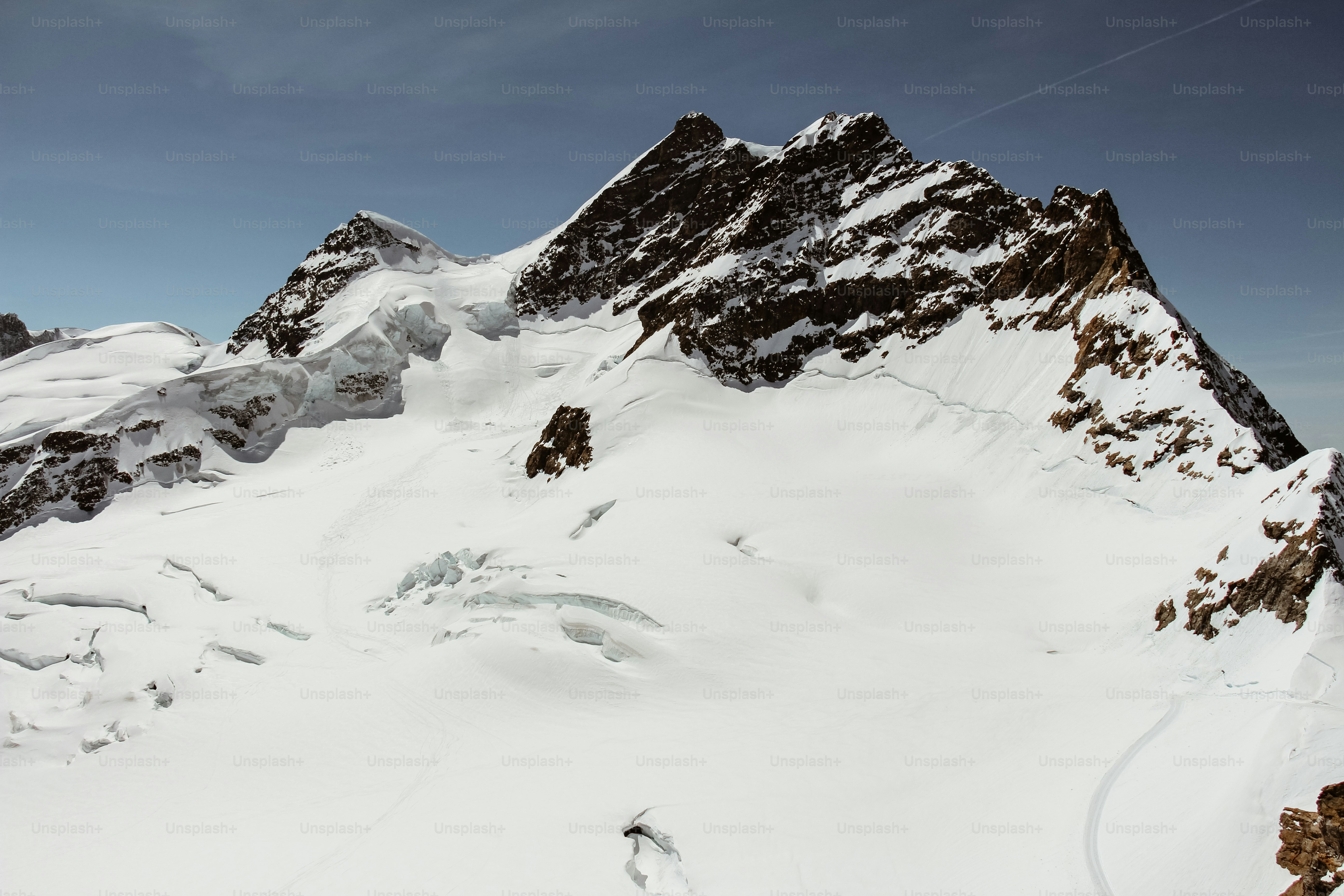 A man riding skis down the side of a snow covered mountain