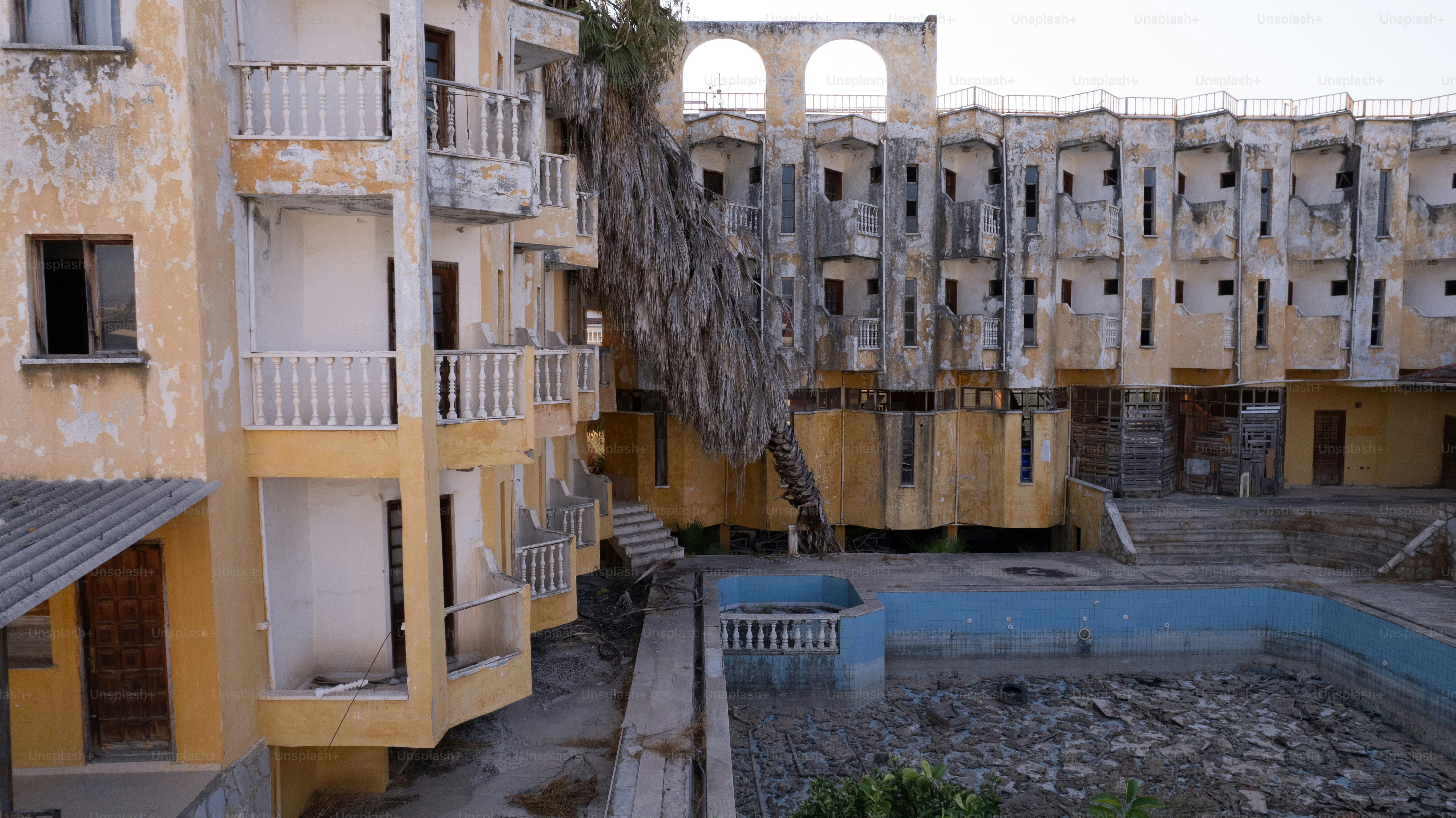An abandoned building with a pool in the middle of it