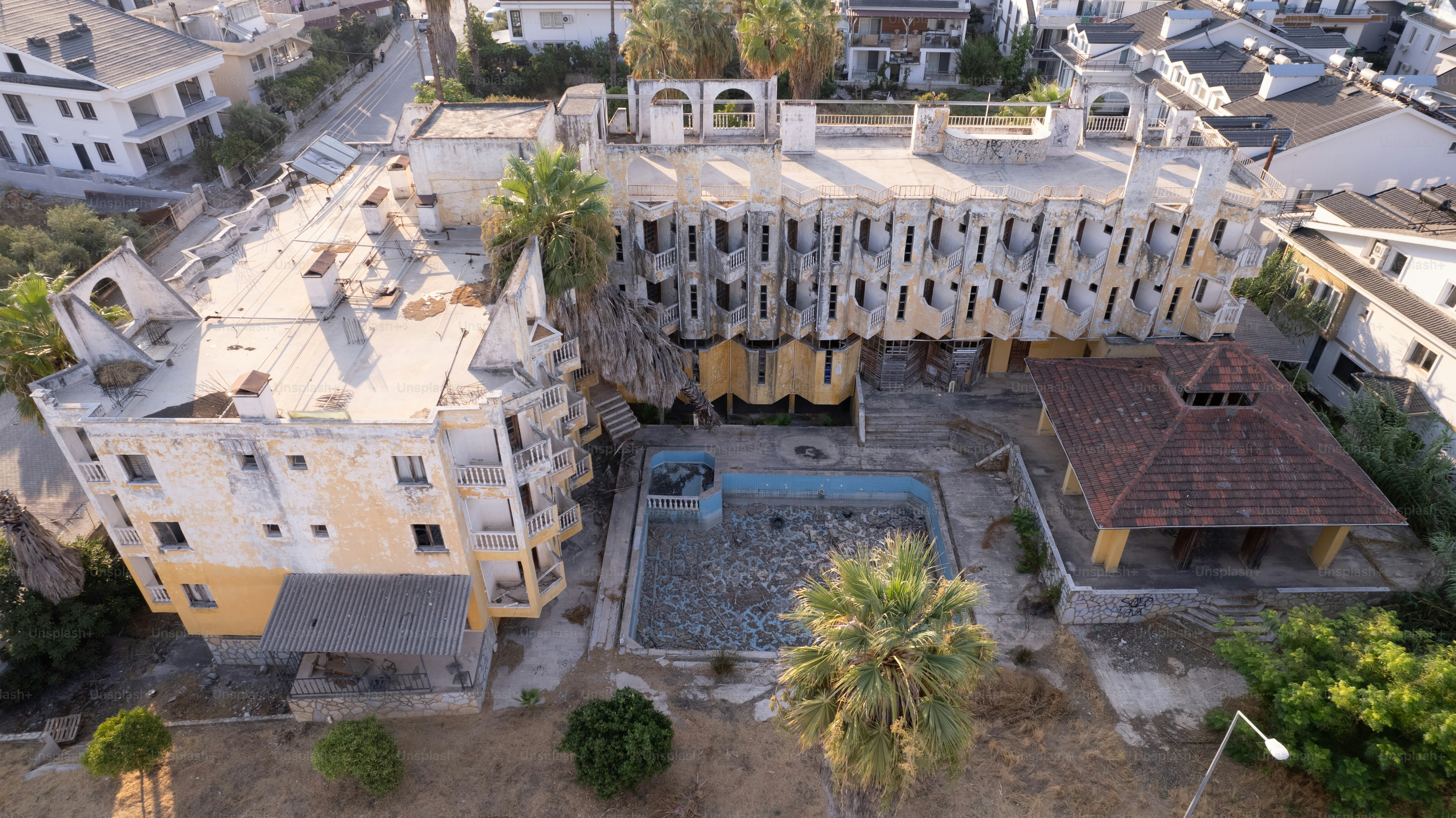 An aerial view of a building with a pool in front of it