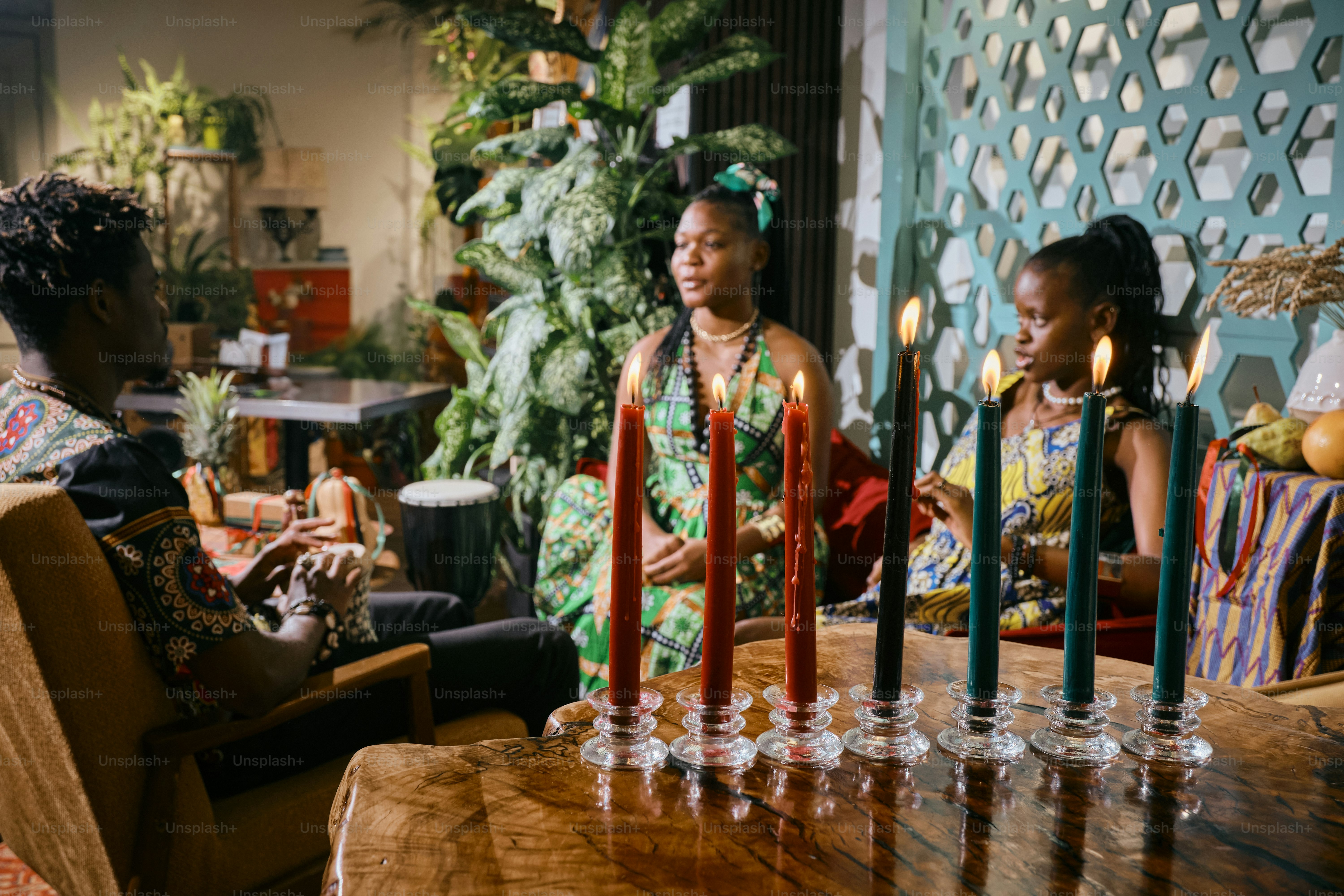 A group of people sitting around a table with candles