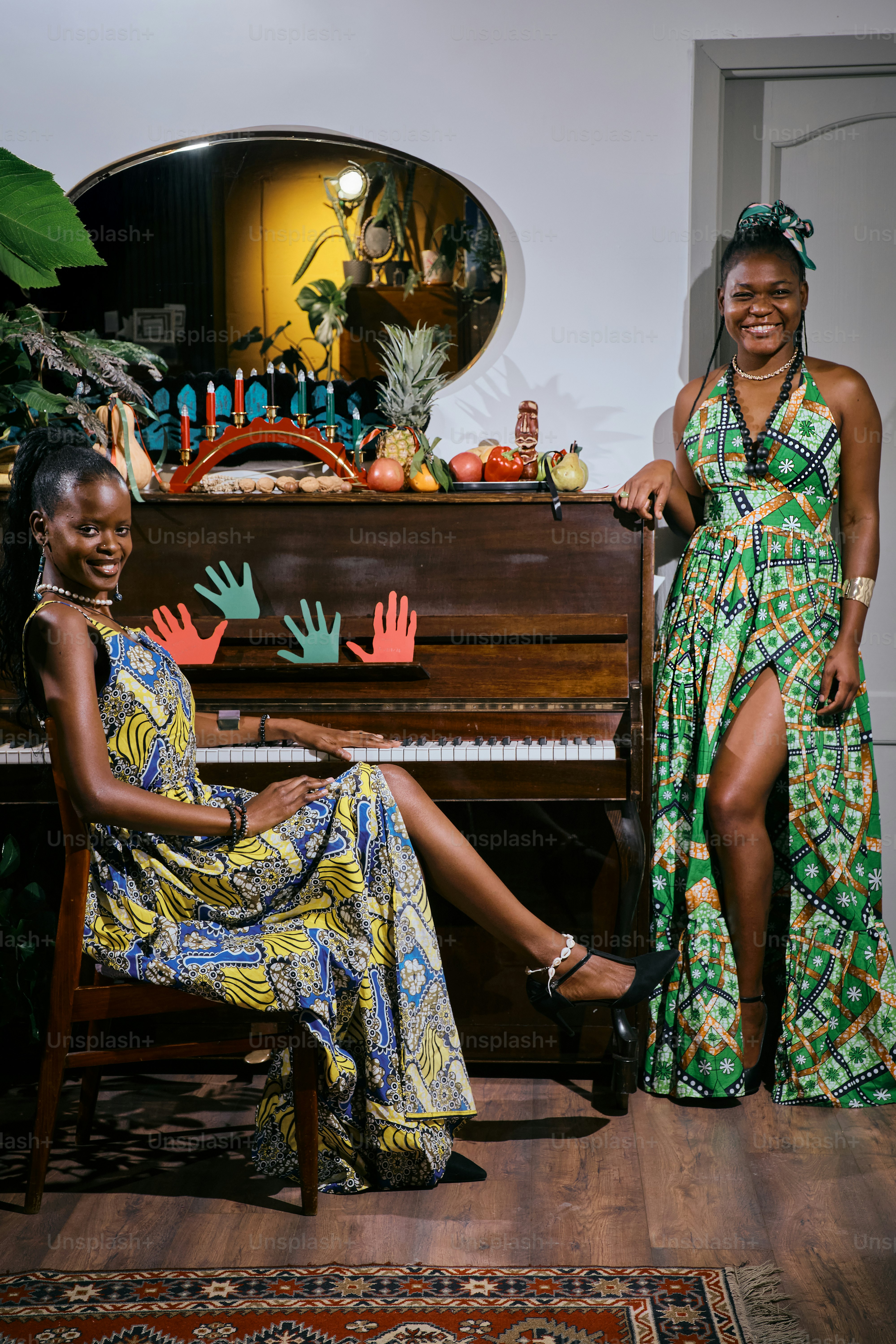Two women sitting at a piano in front of a mirror