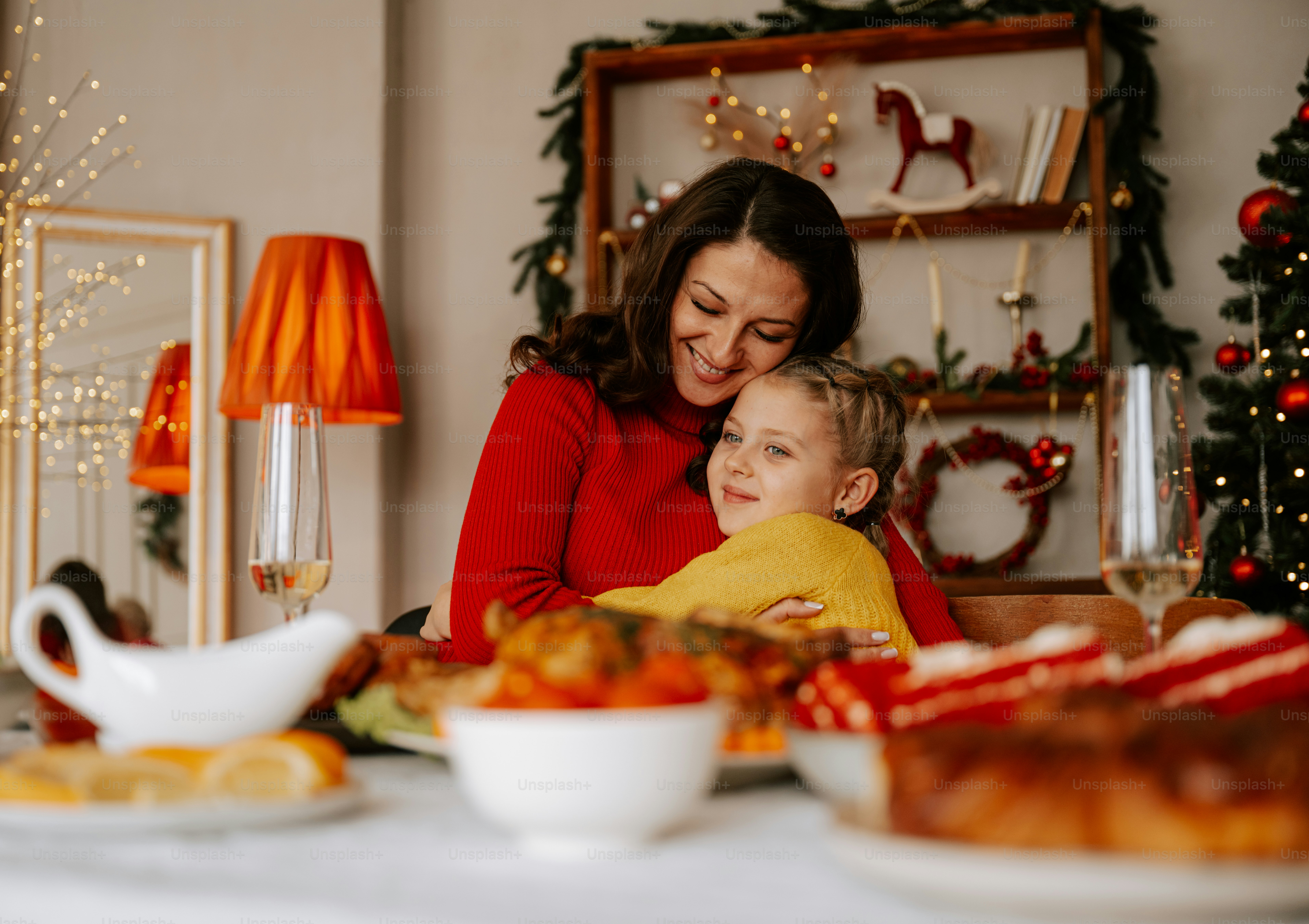 A woman and a child sitting at a table with food
