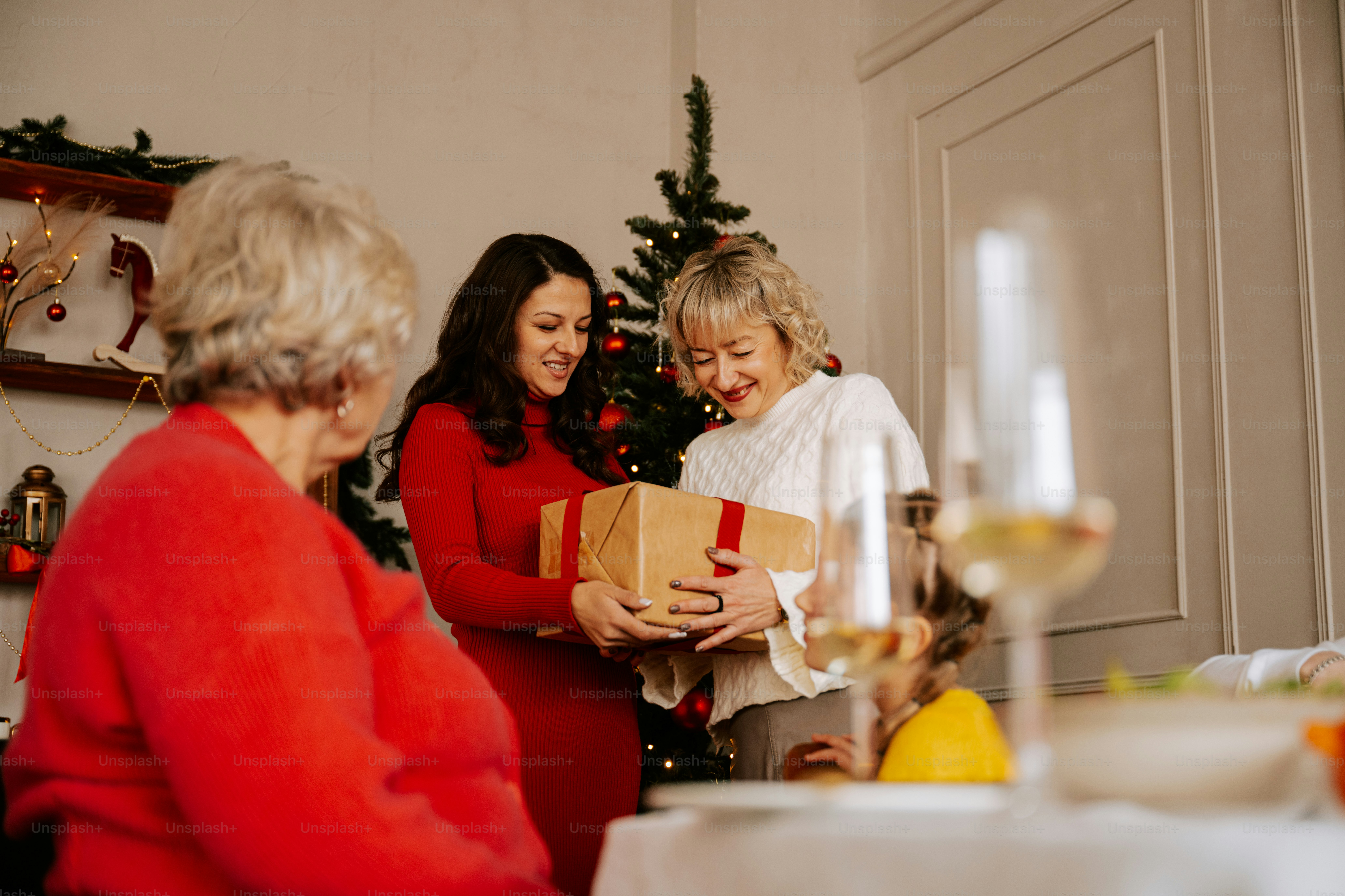 A group of women standing around a christmas tree