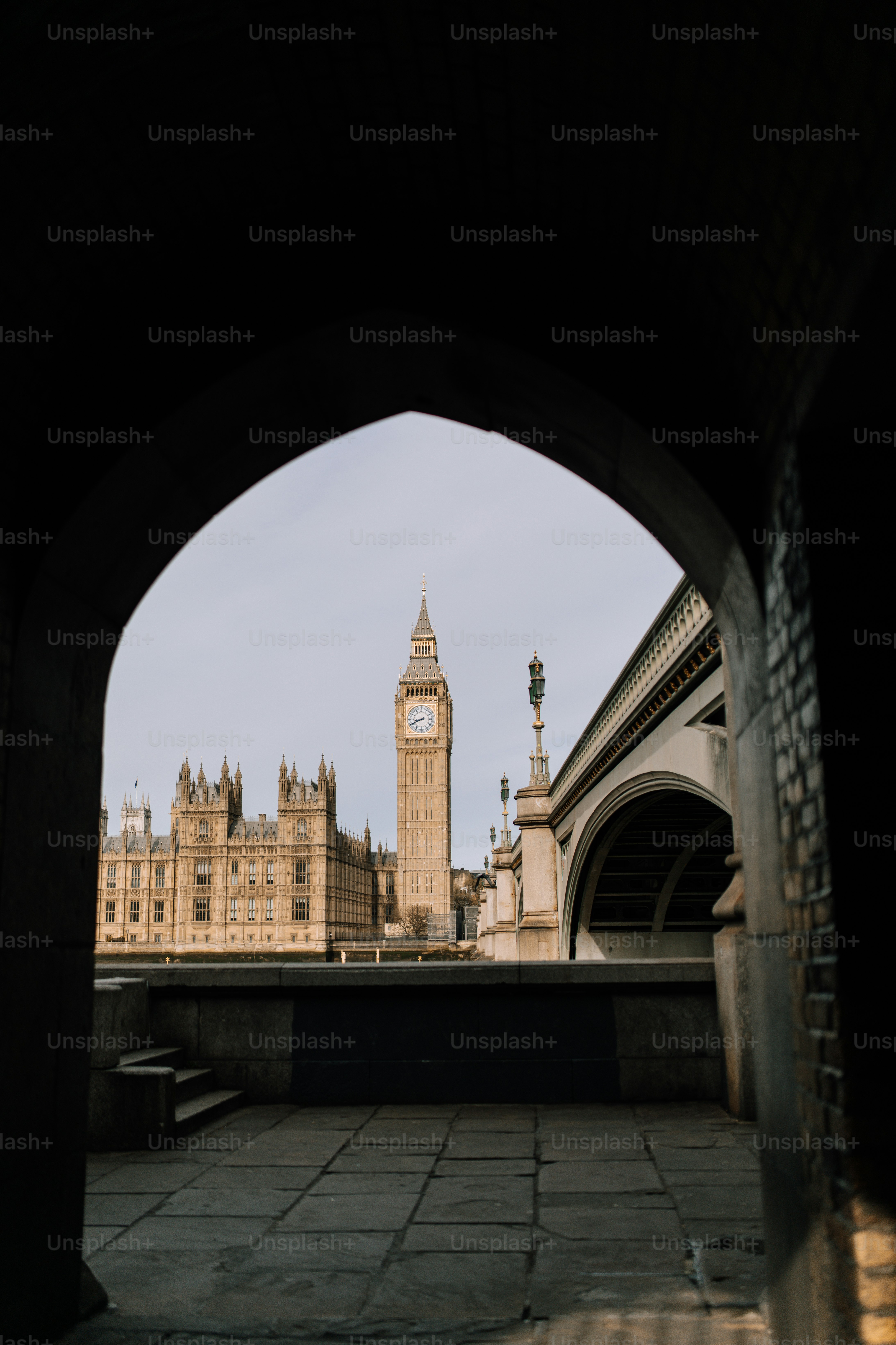 A clock tower towering over a city next to a bridge