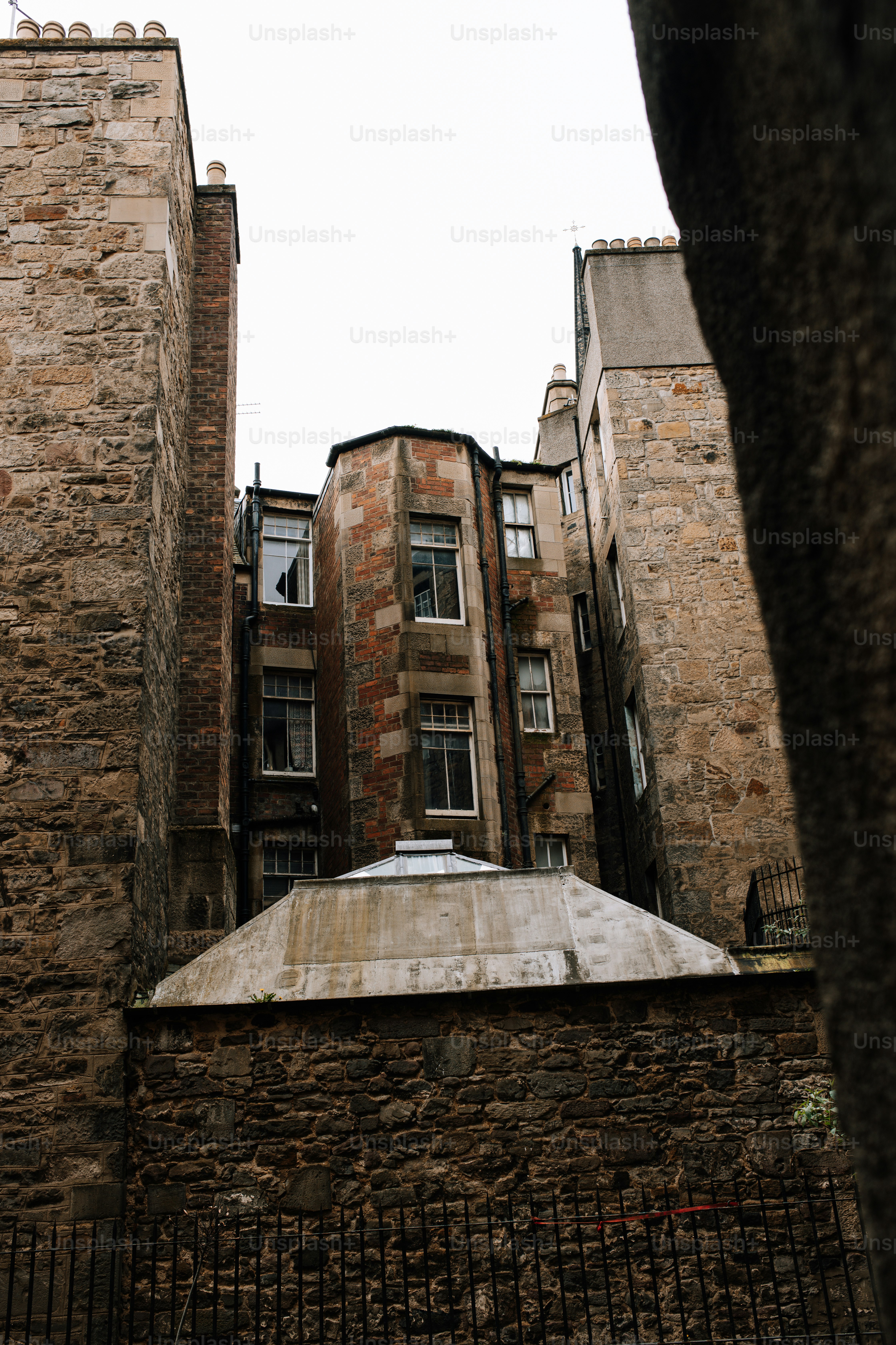 A tall brick building sitting next to a tree