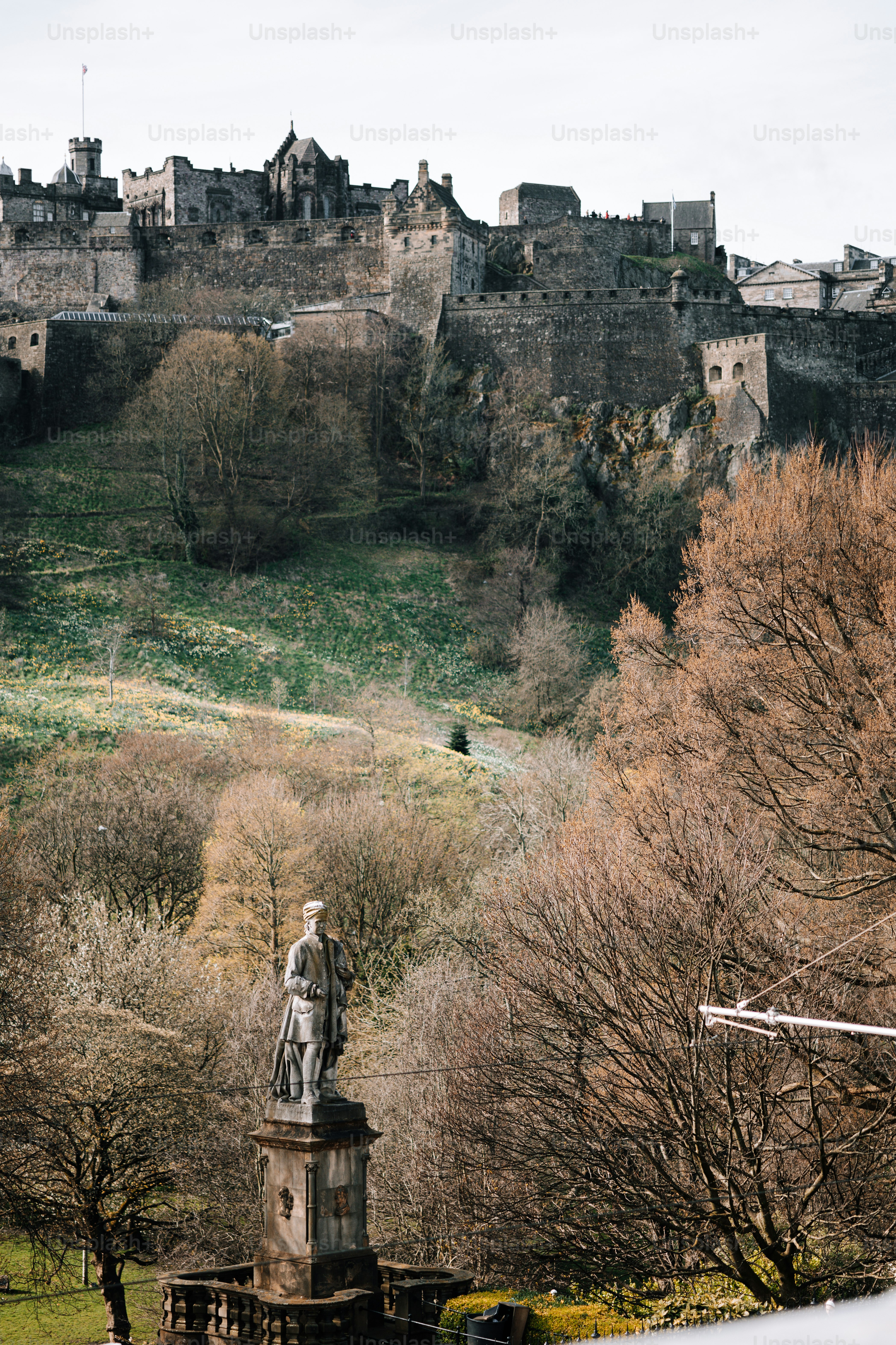 A view of a castle with a statue in the foreground