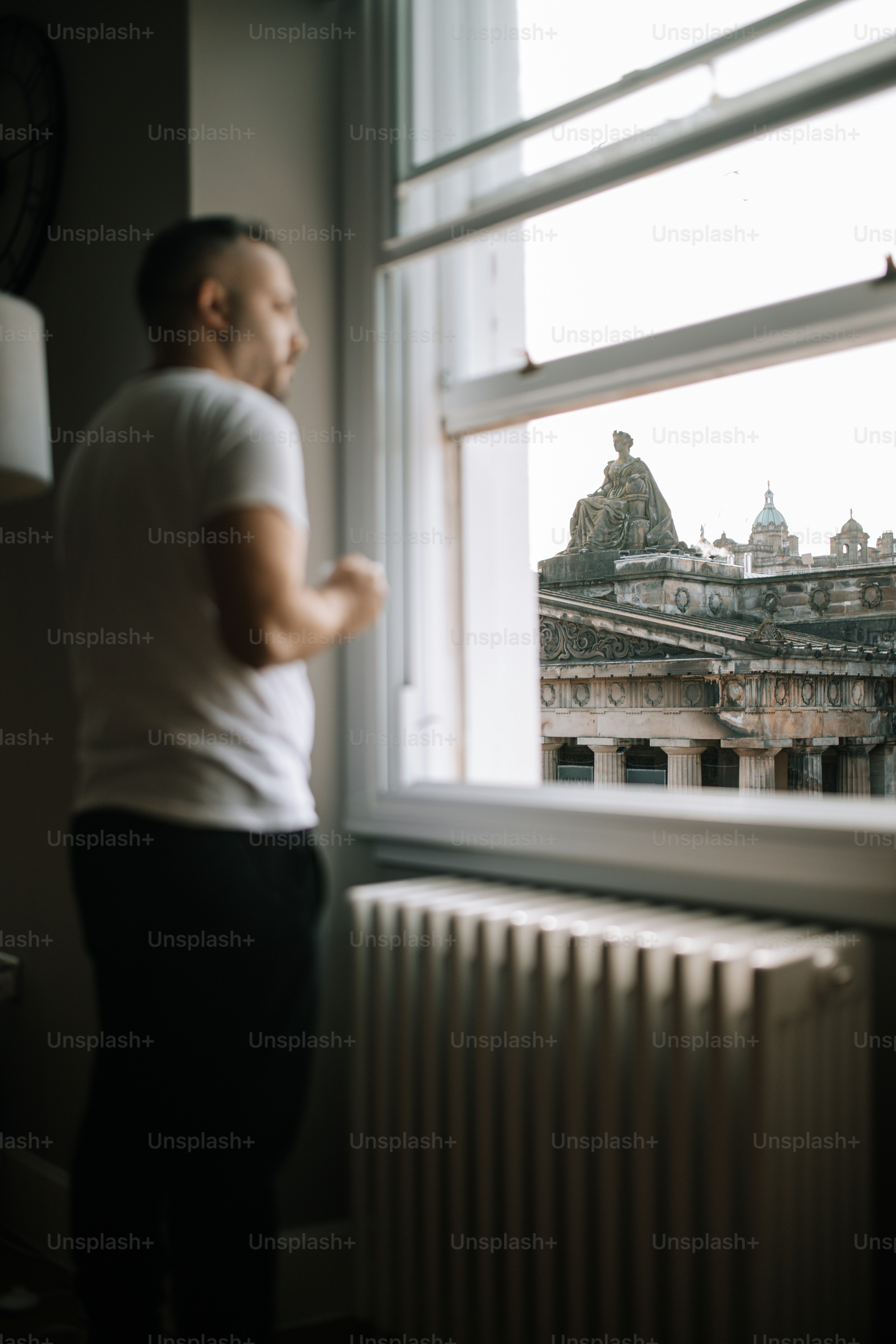 A man looking out a window at a city photo – Travel Image on Unsplash