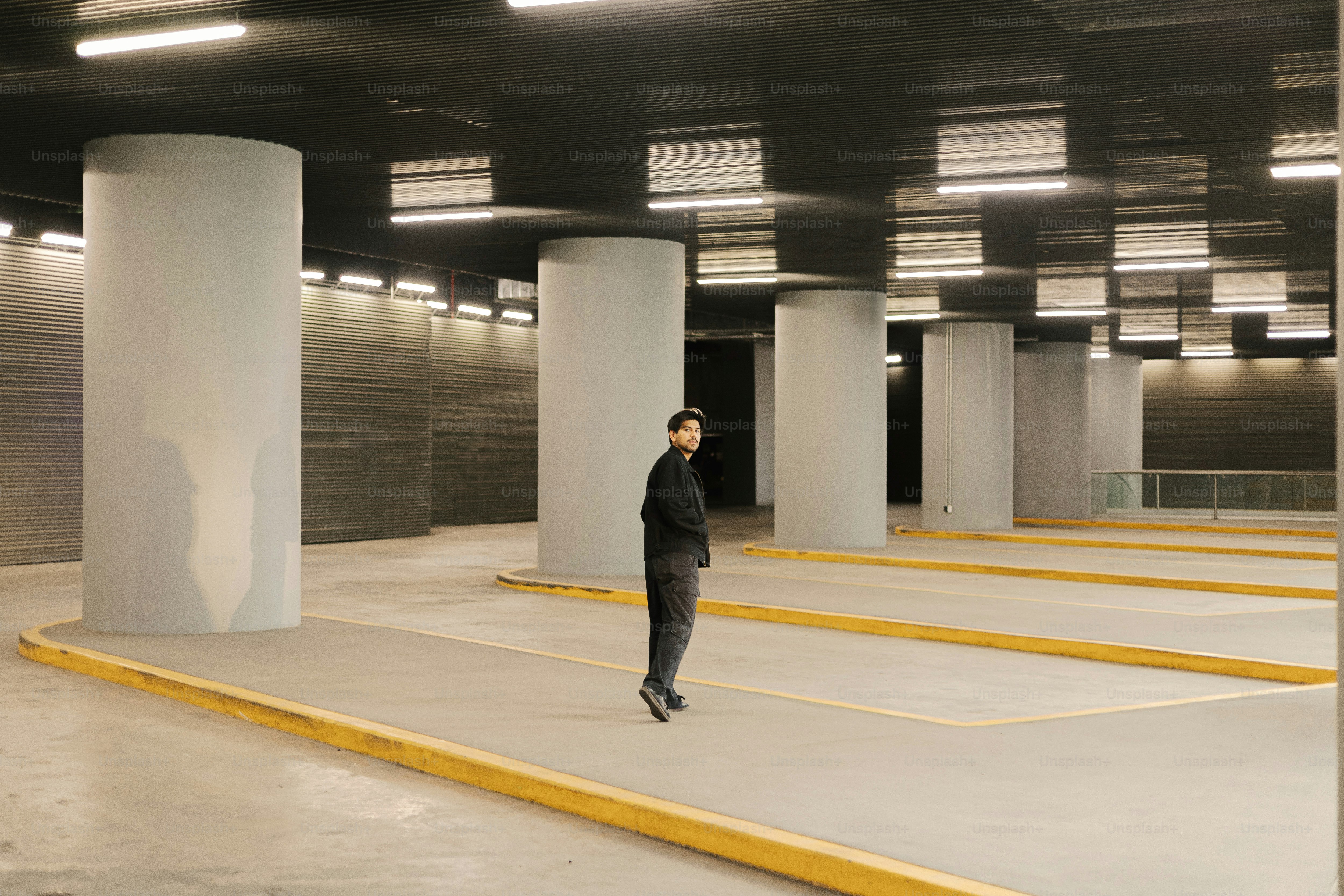 A man is standing in a parking garage