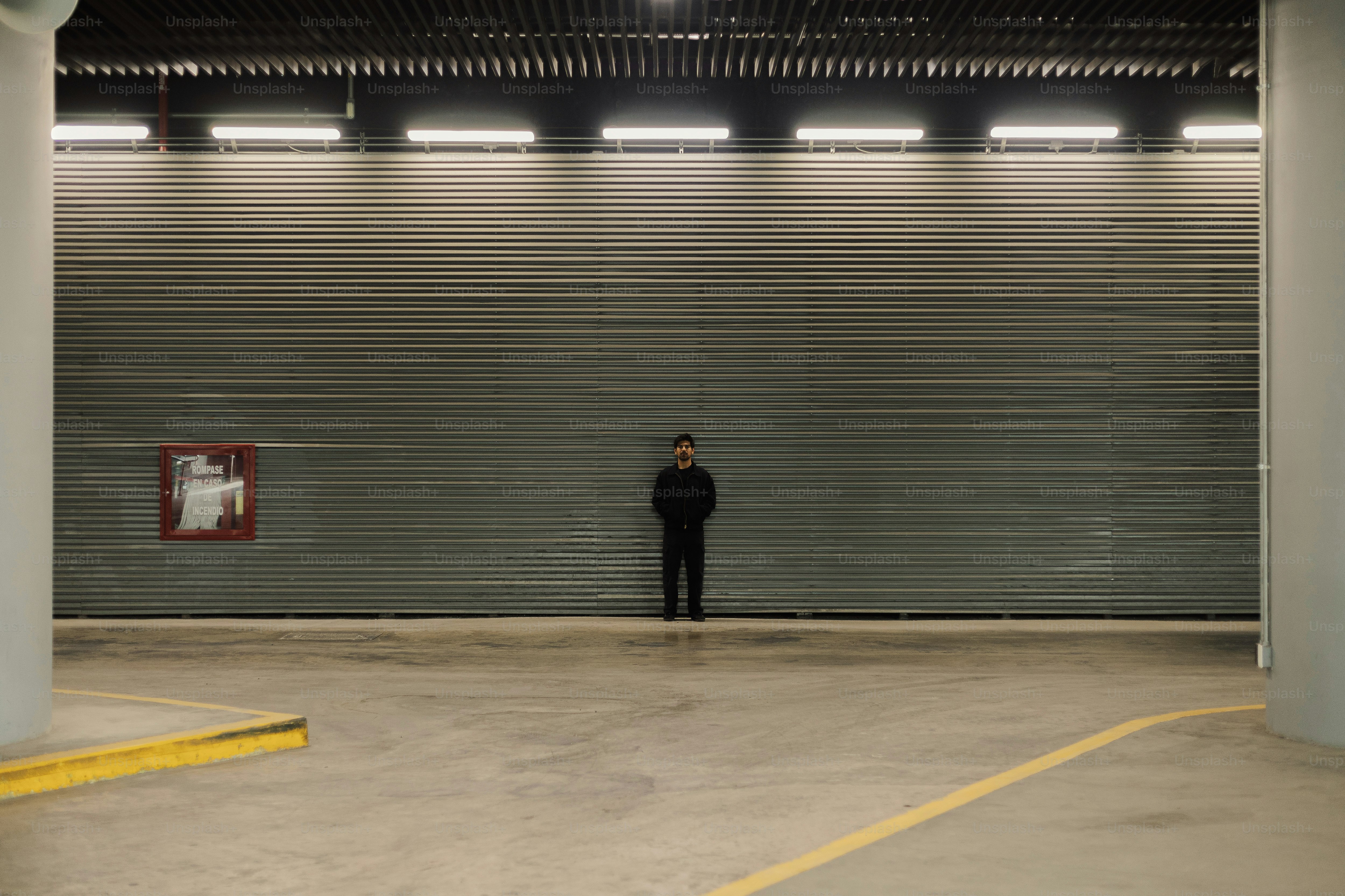 A man standing in a parking garage with his back to the camera