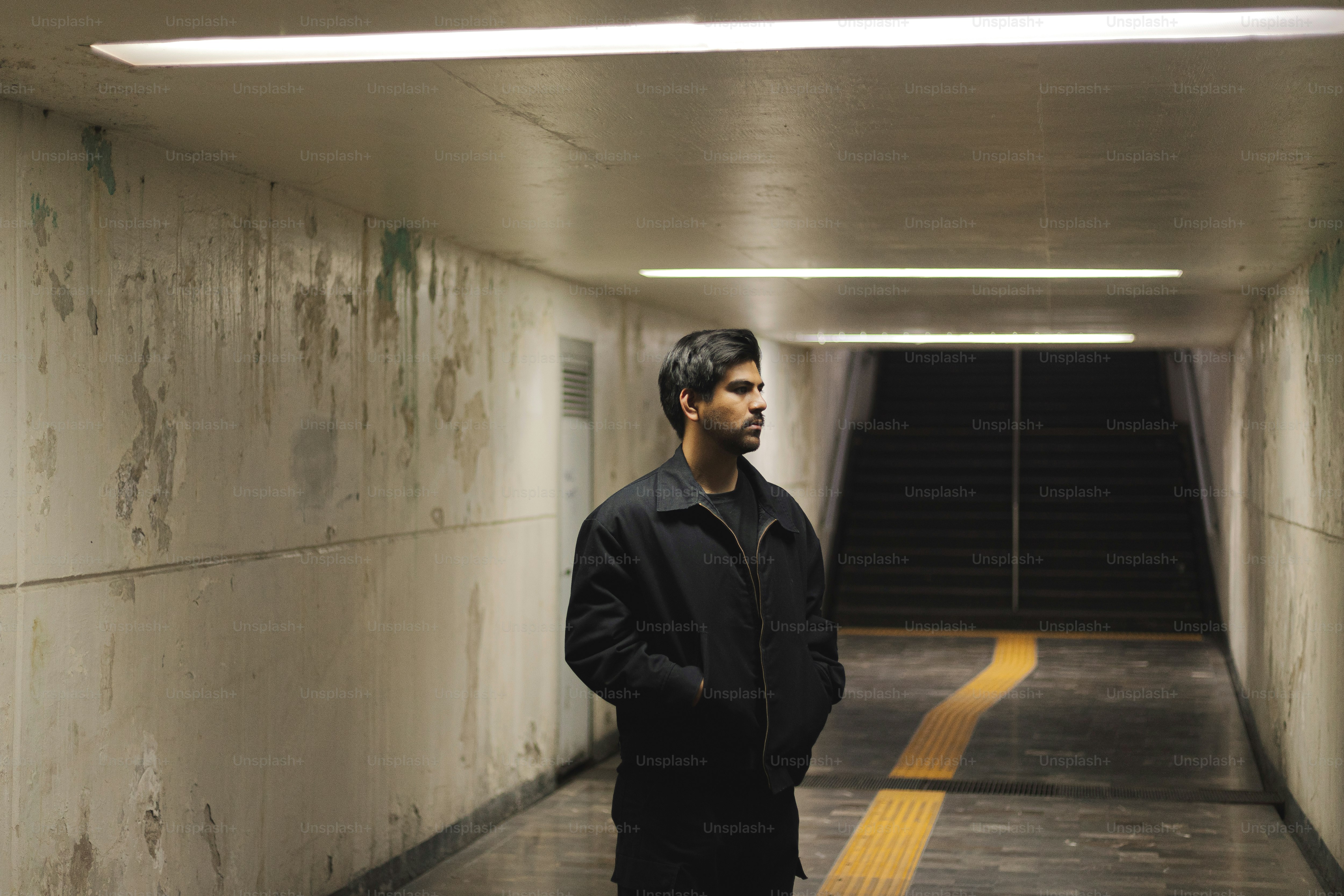 A man standing in a tunnel with his hands in his pockets