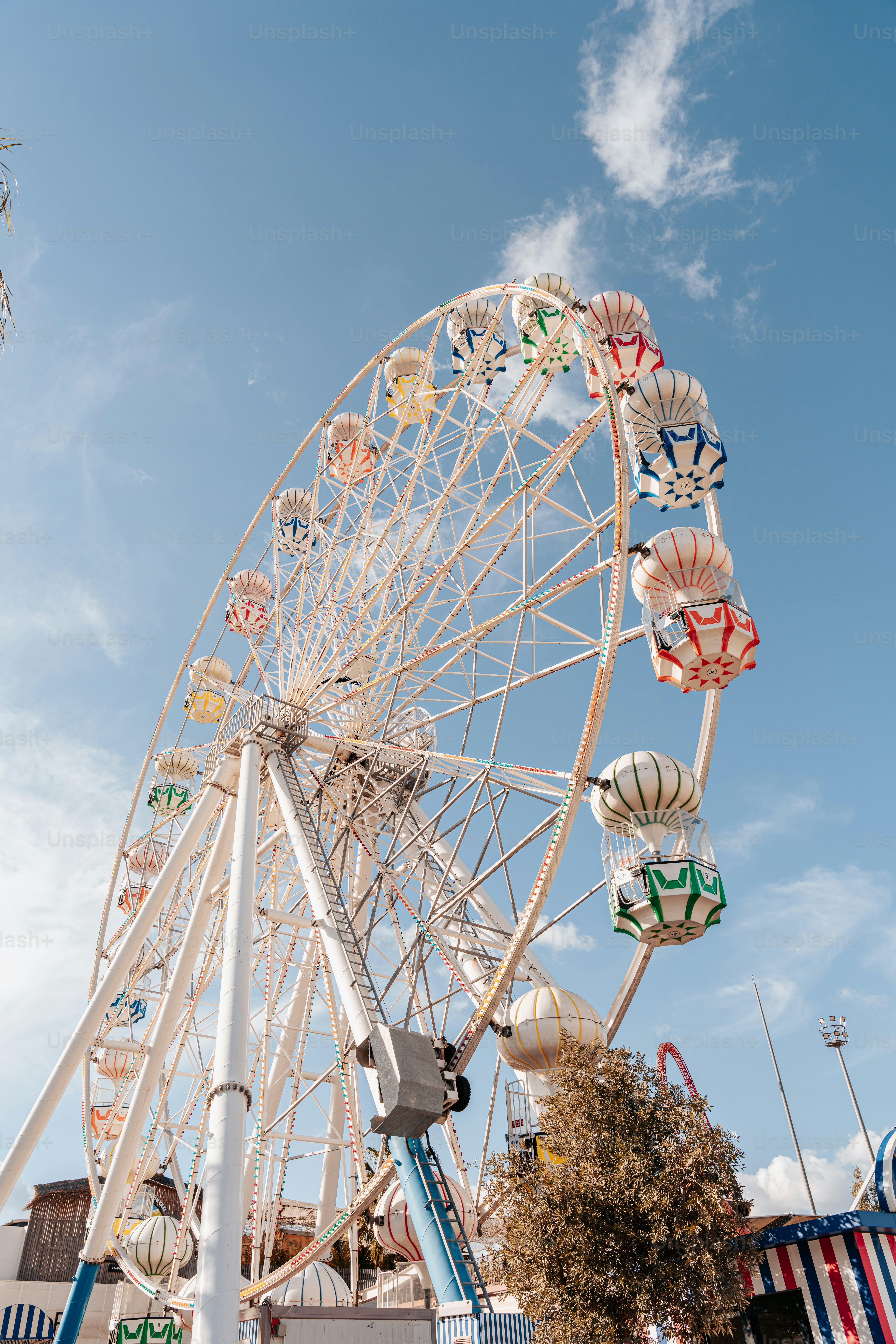A large ferris wheel sitting next to a tall building photo – Fairground ...