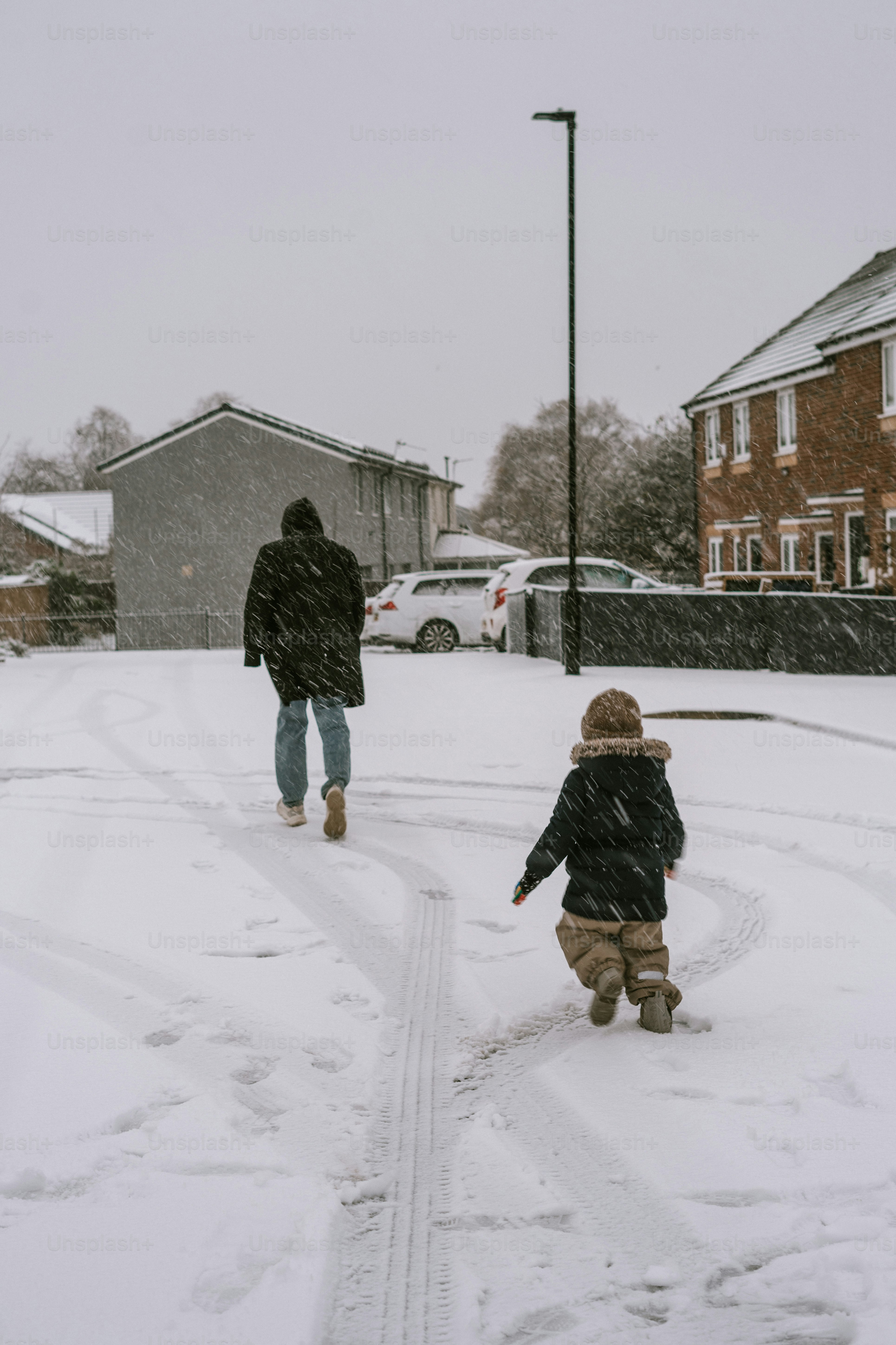 A man and a child walking in the snow