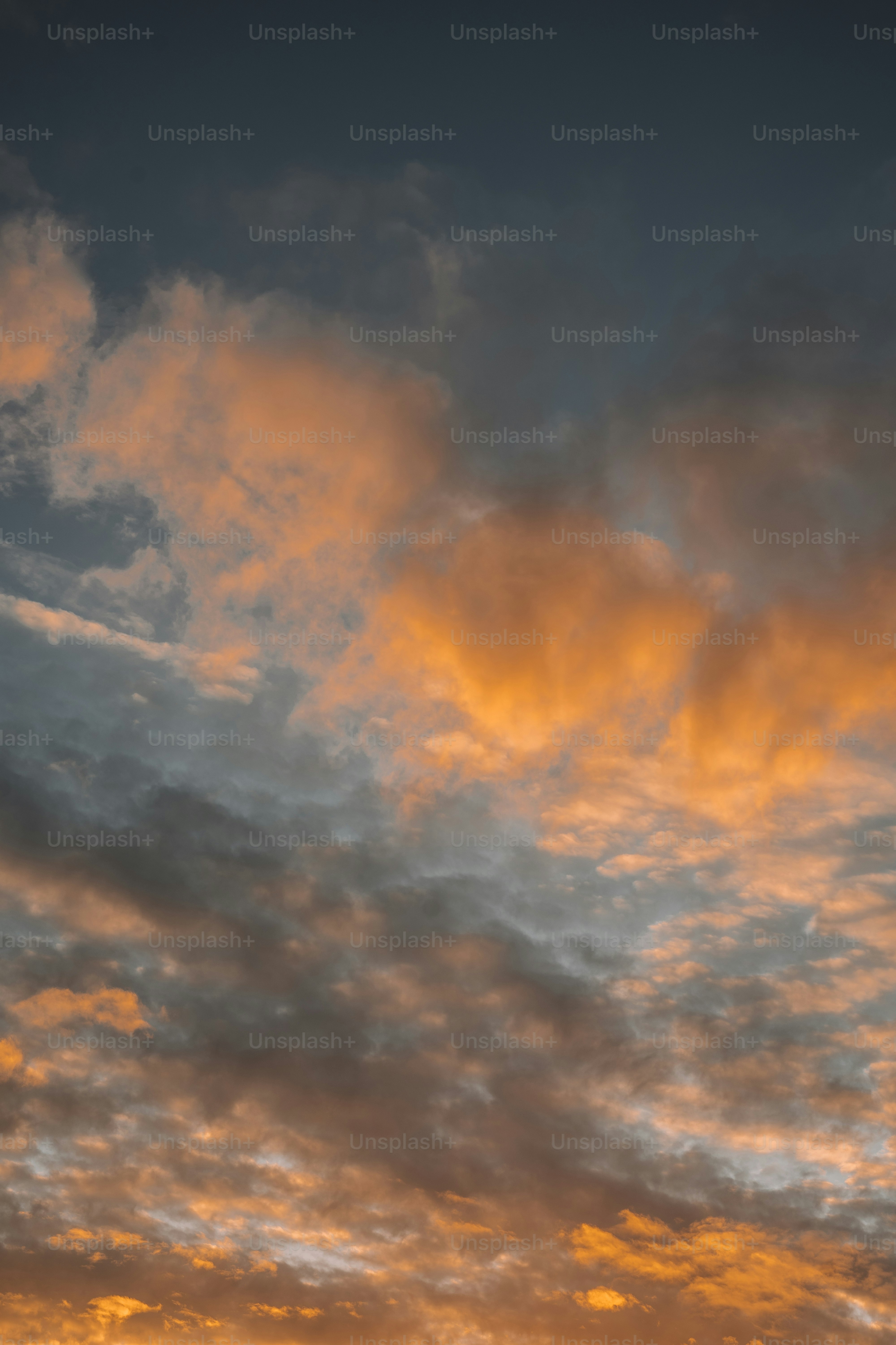 A plane flying in the sky at sunset