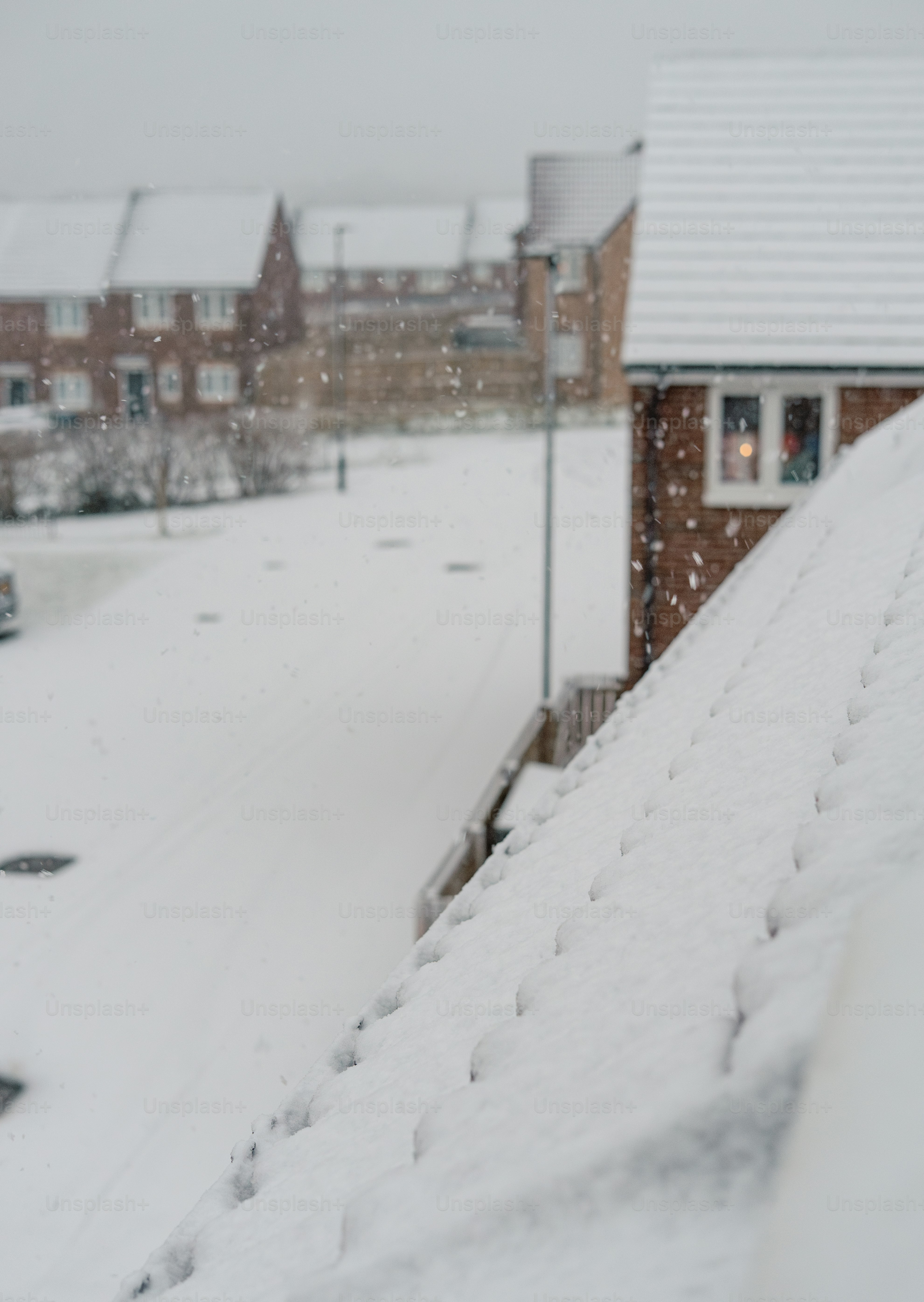 A snow covered street with cars parked on the side of it