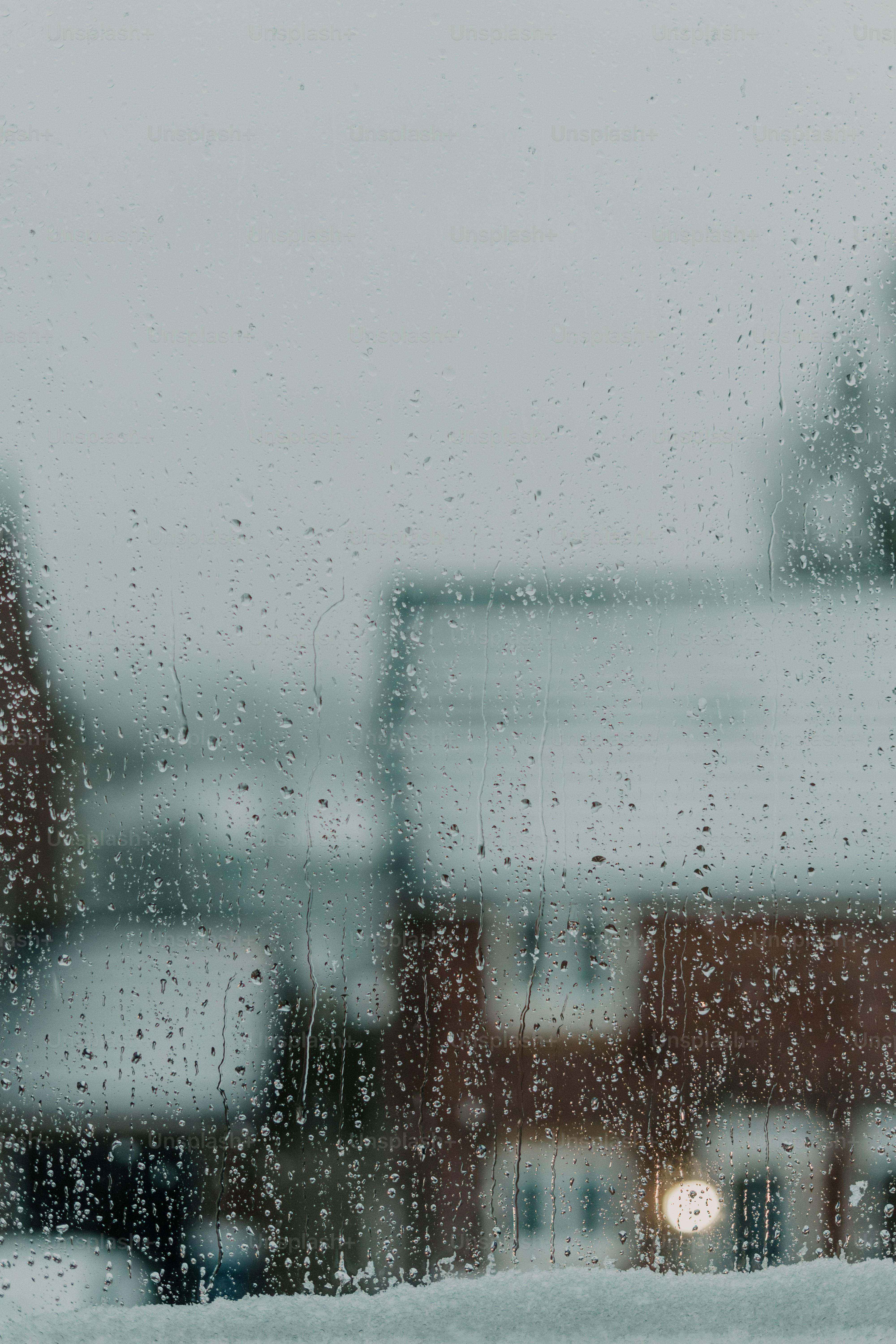 A view of a building through a rain covered window