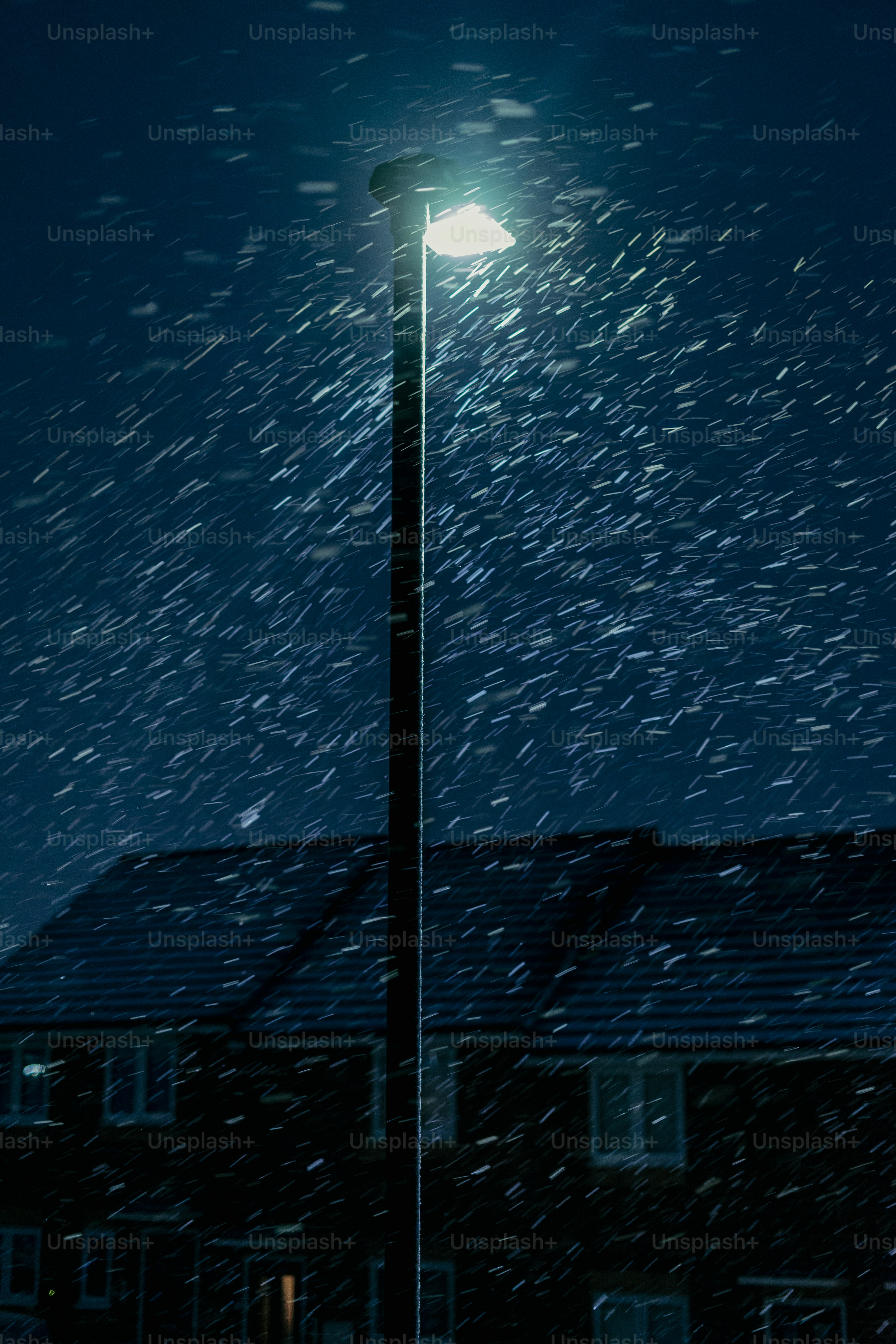 A street light in the snow at night