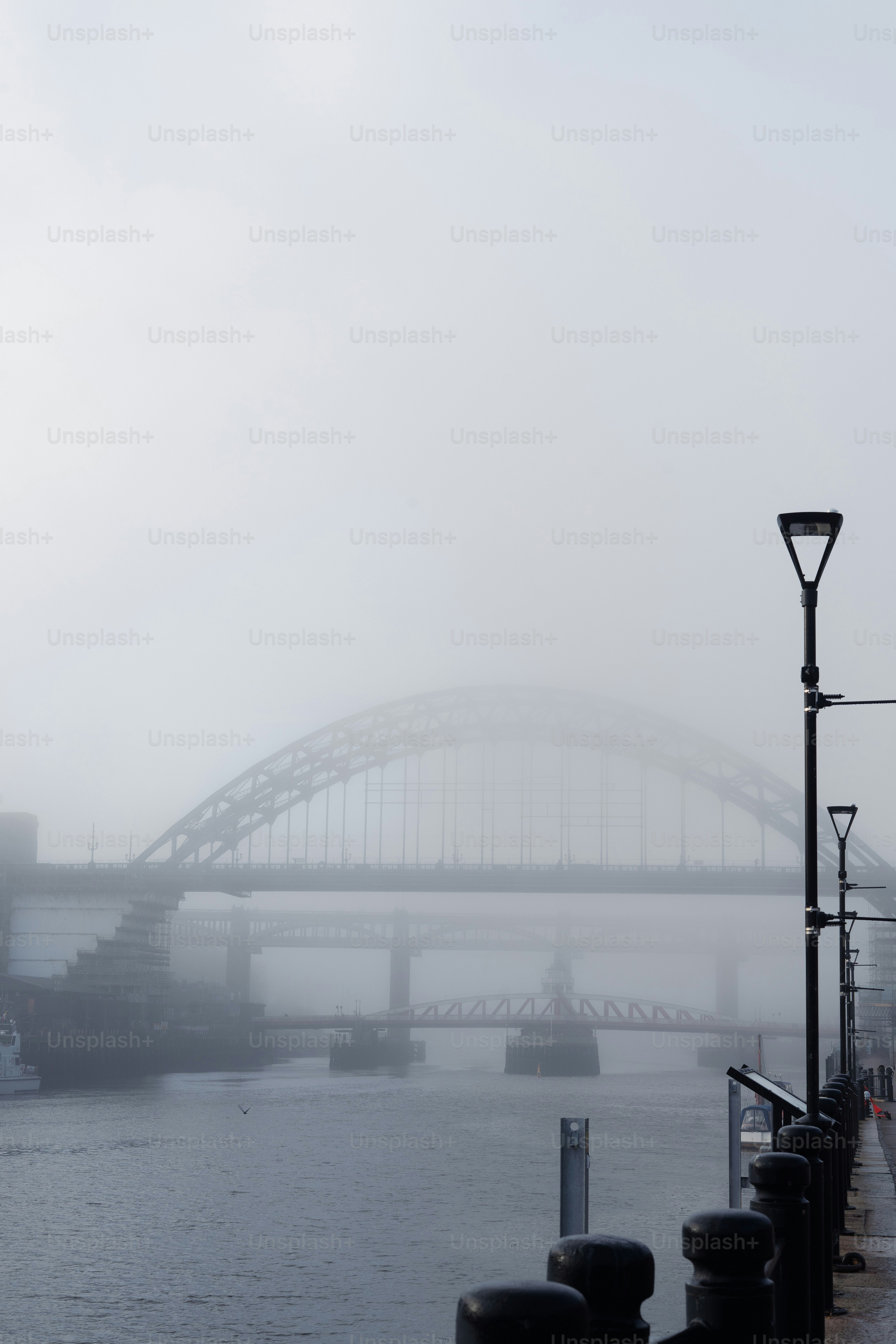 A foggy river with a bridge in the background