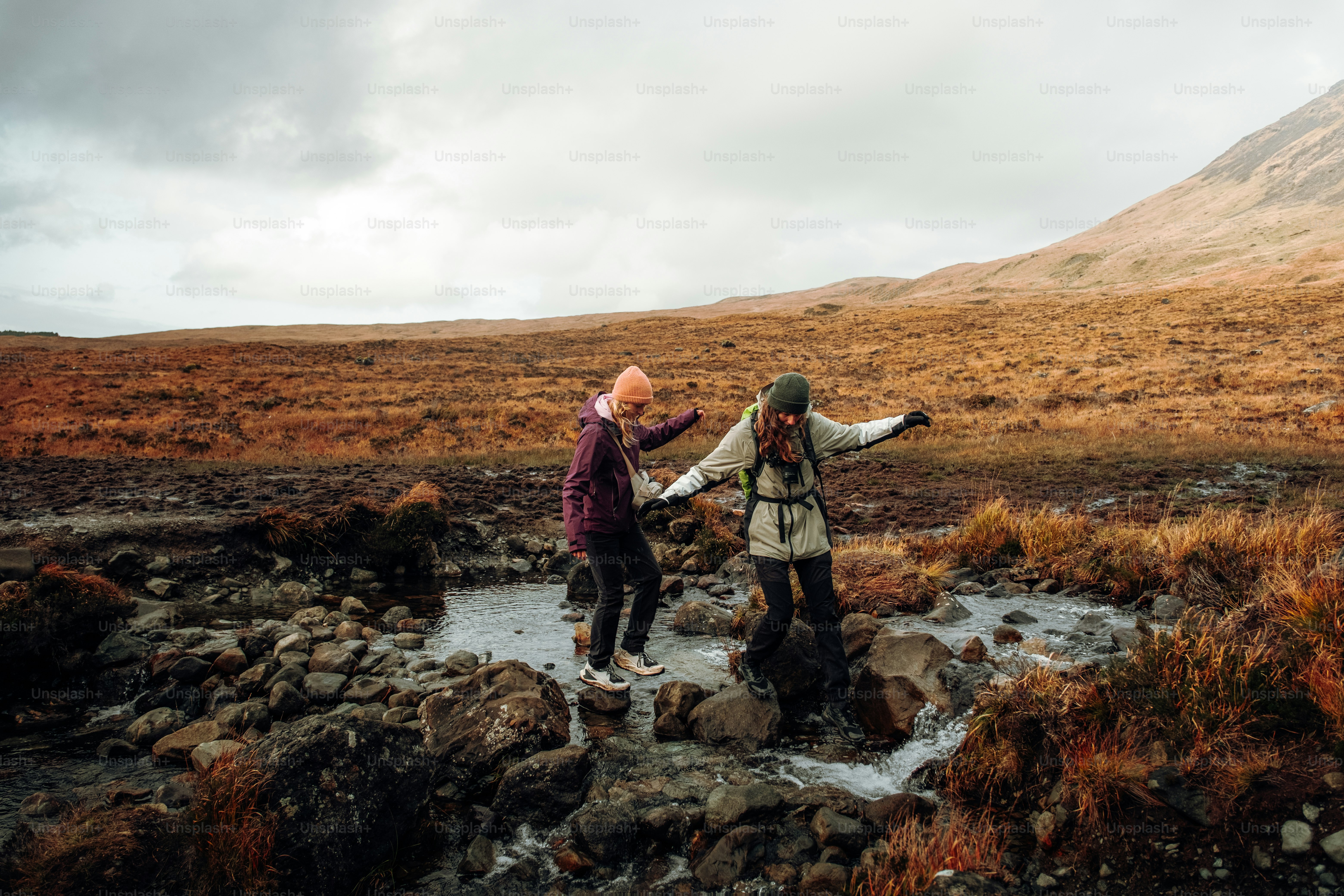 A couple of people standing on top of a rocky hillside
