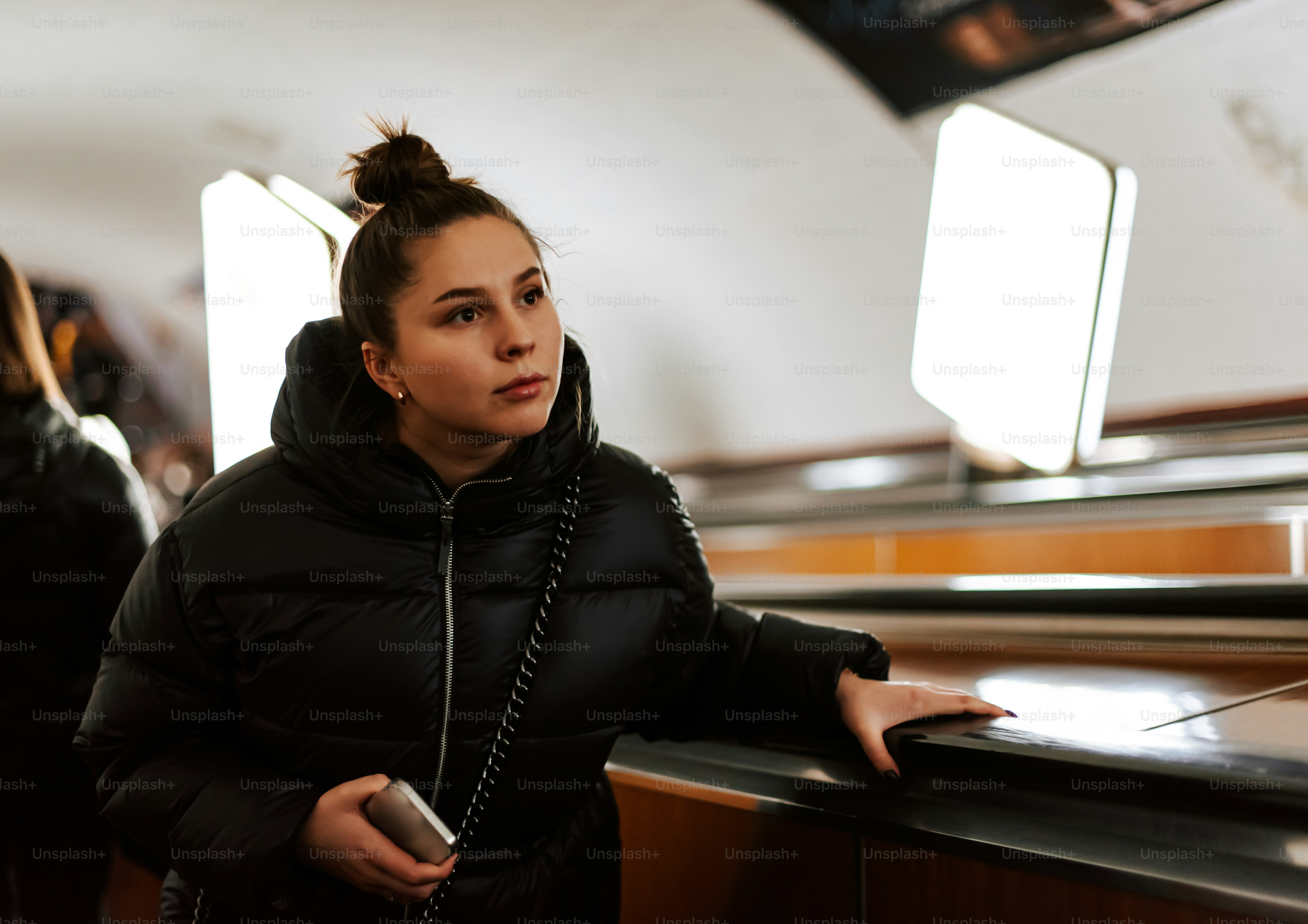 A woman in a black jacket leaning on a rail