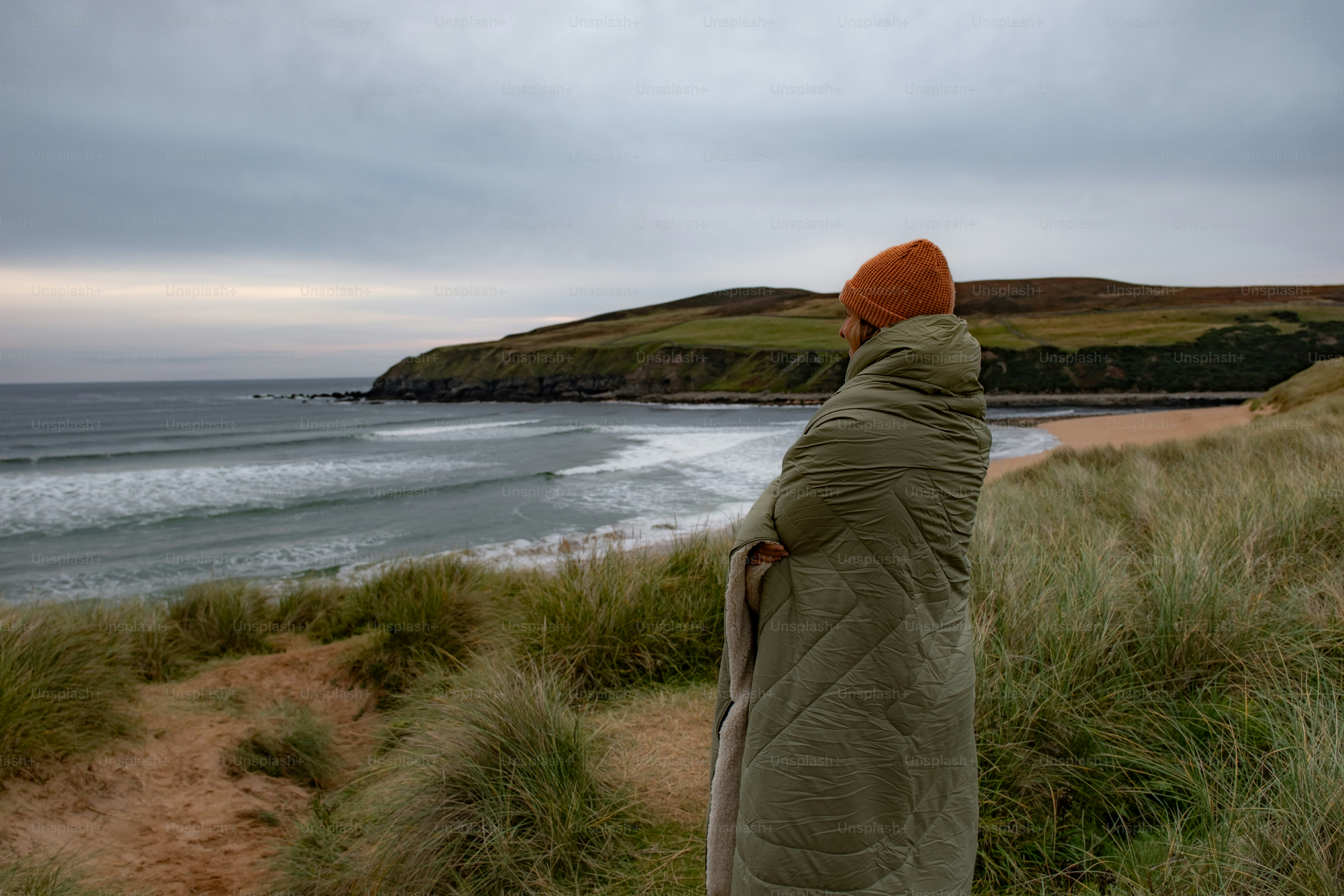 A man standing on top of a lush green hillside