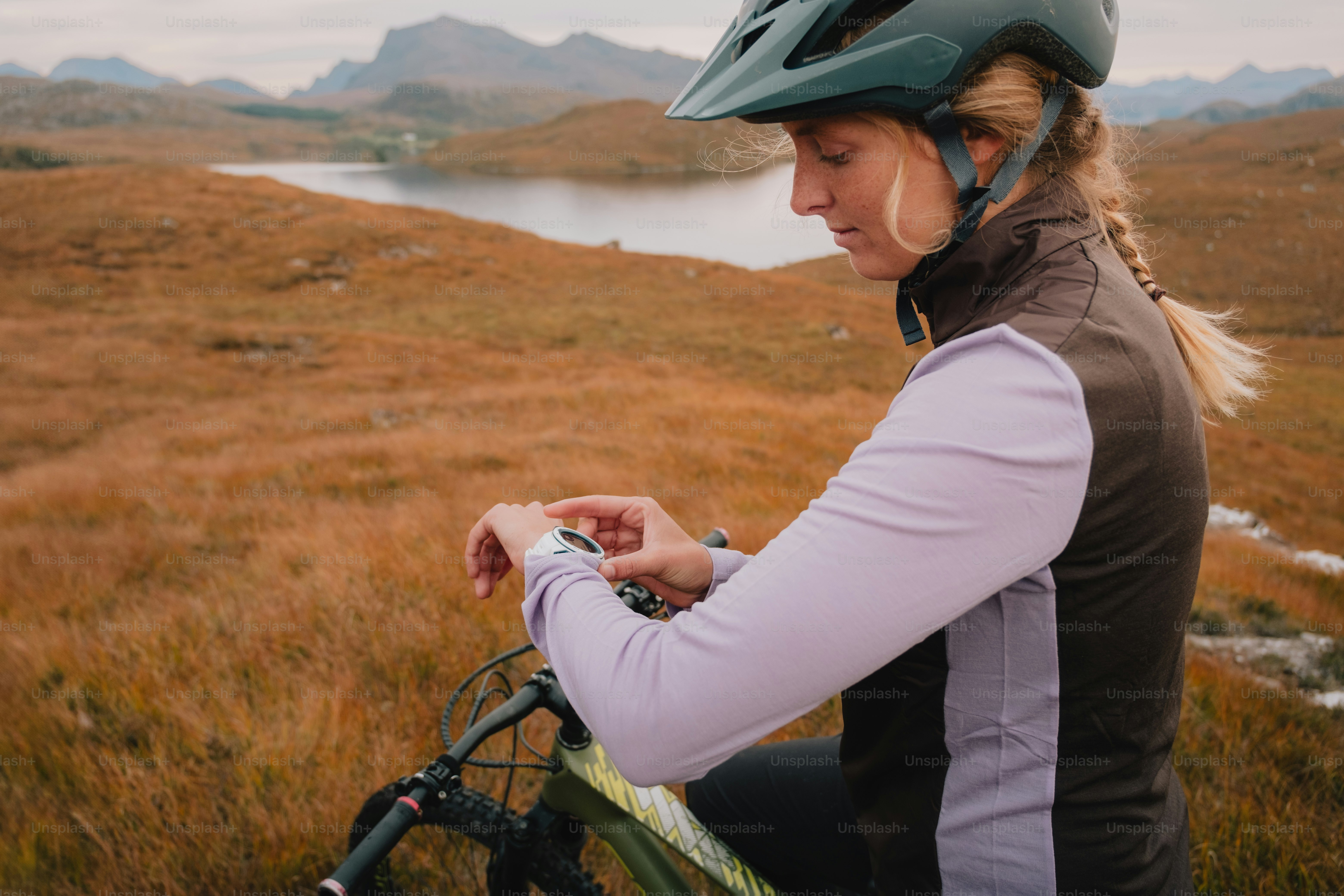 A woman riding a bike on top of a grass covered field