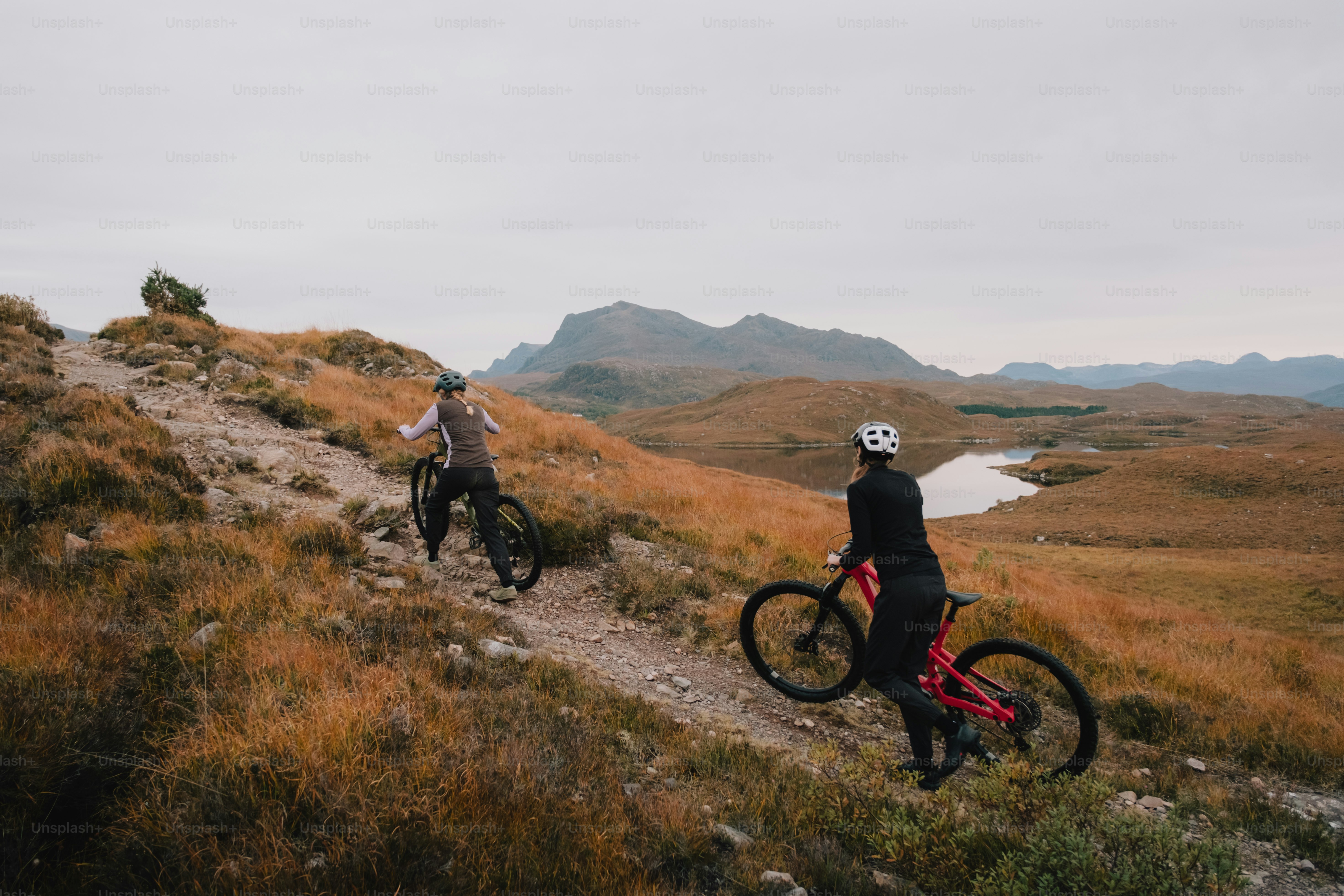 A couple of people riding bikes down a hill