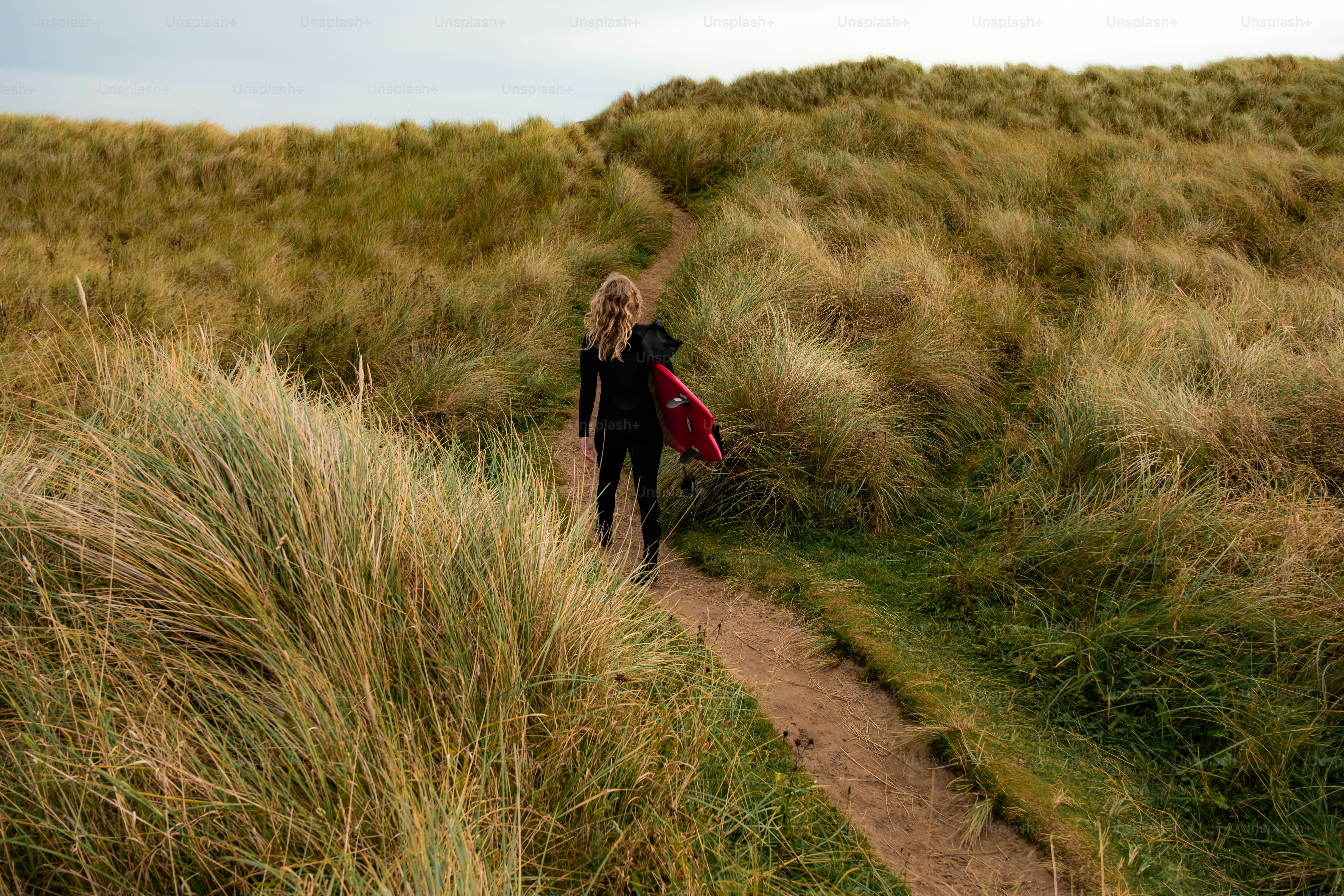 A person walking up a path in a grassy area