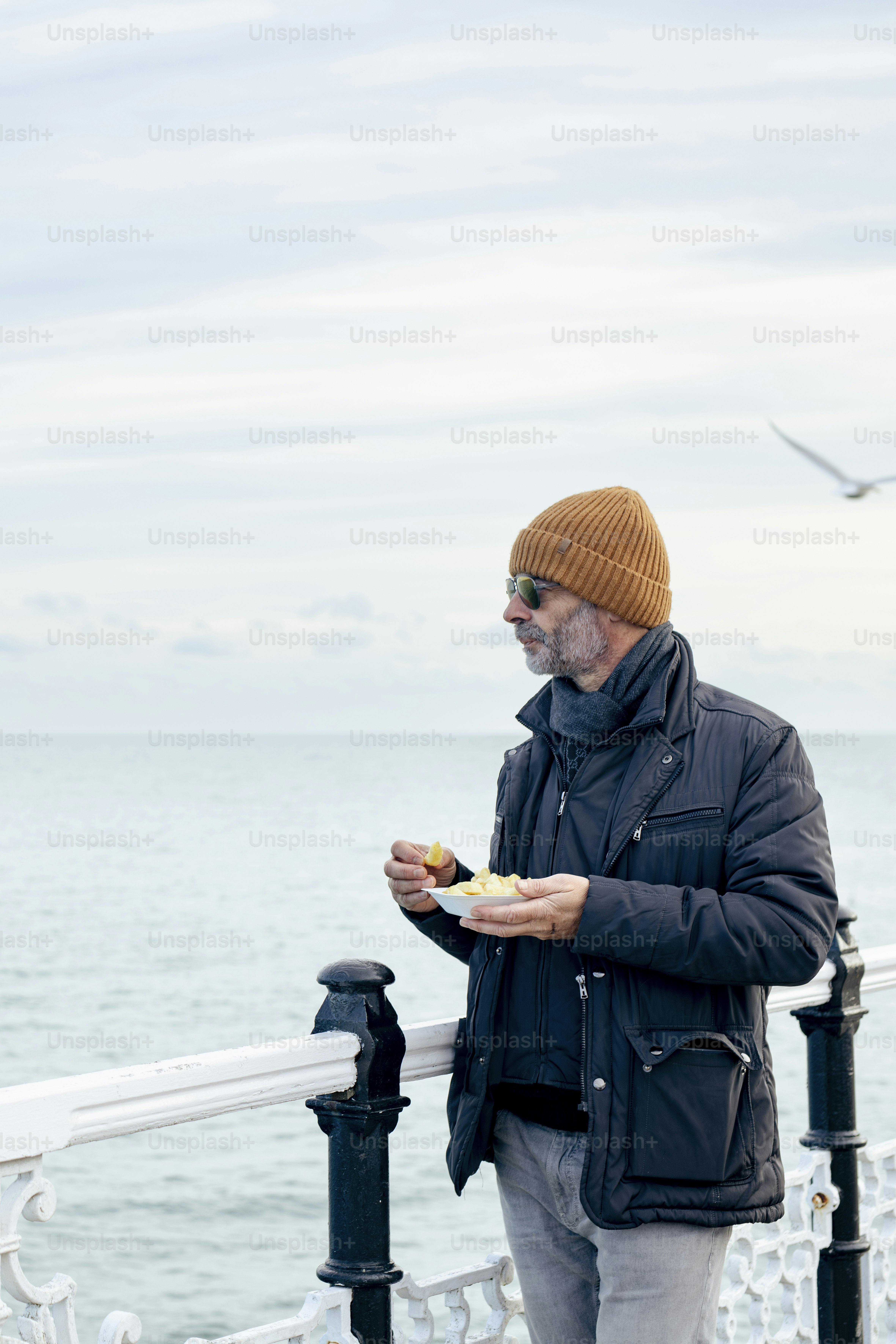 Un hombre de pie en un muelle comiendo comida
