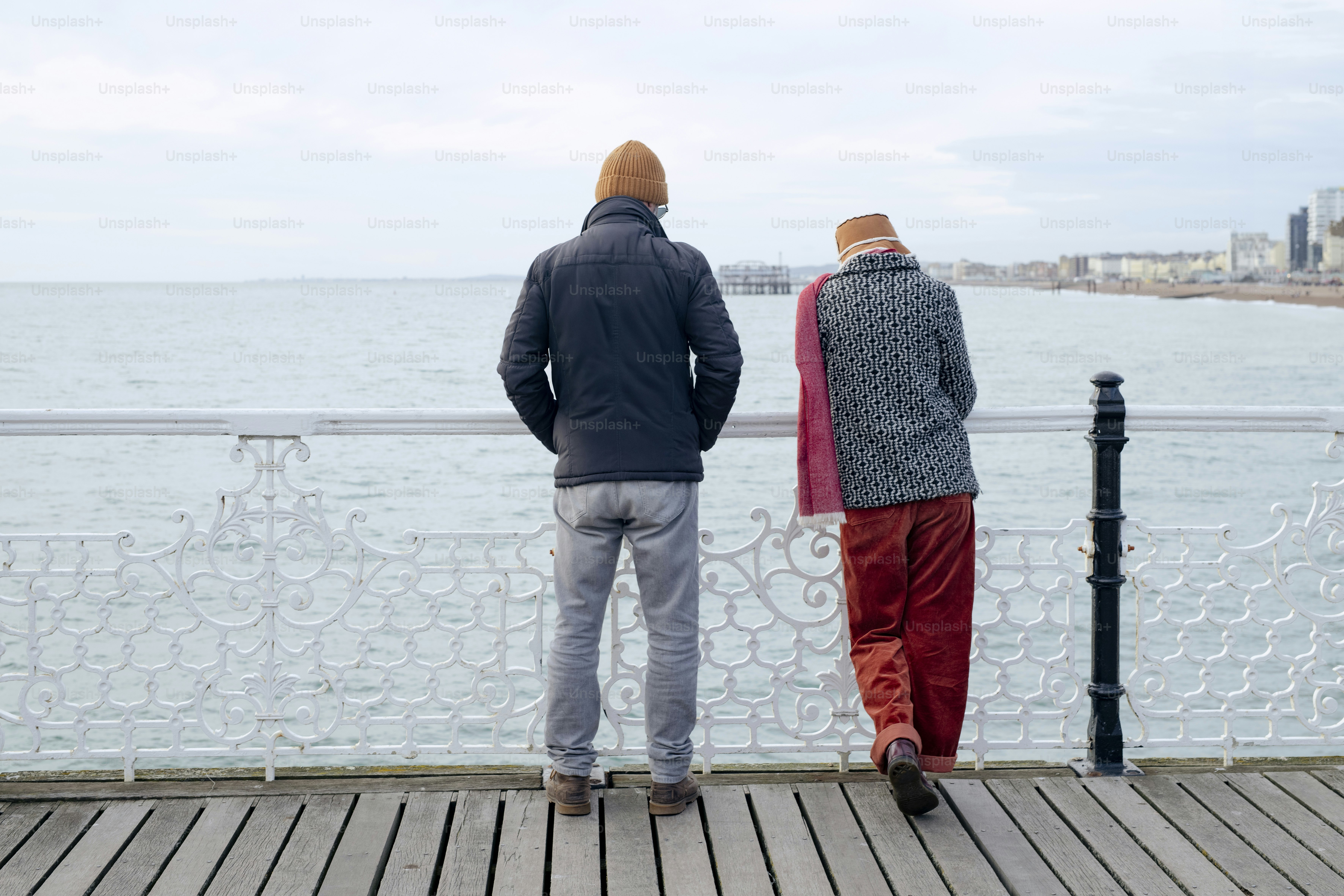 Dos personas de pie en un muelle mirando el agua