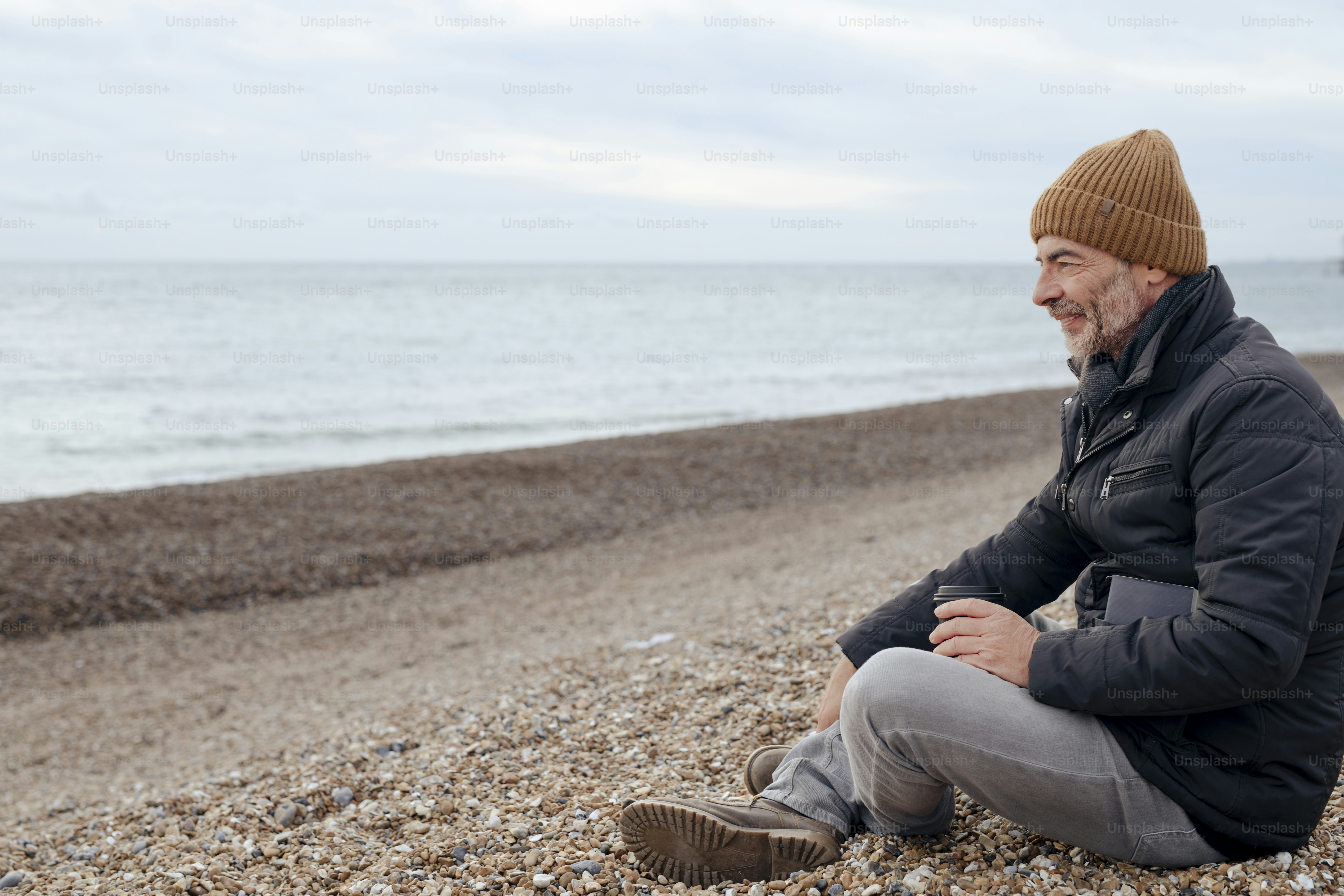 Un hombre sentado en una playa junto al océano