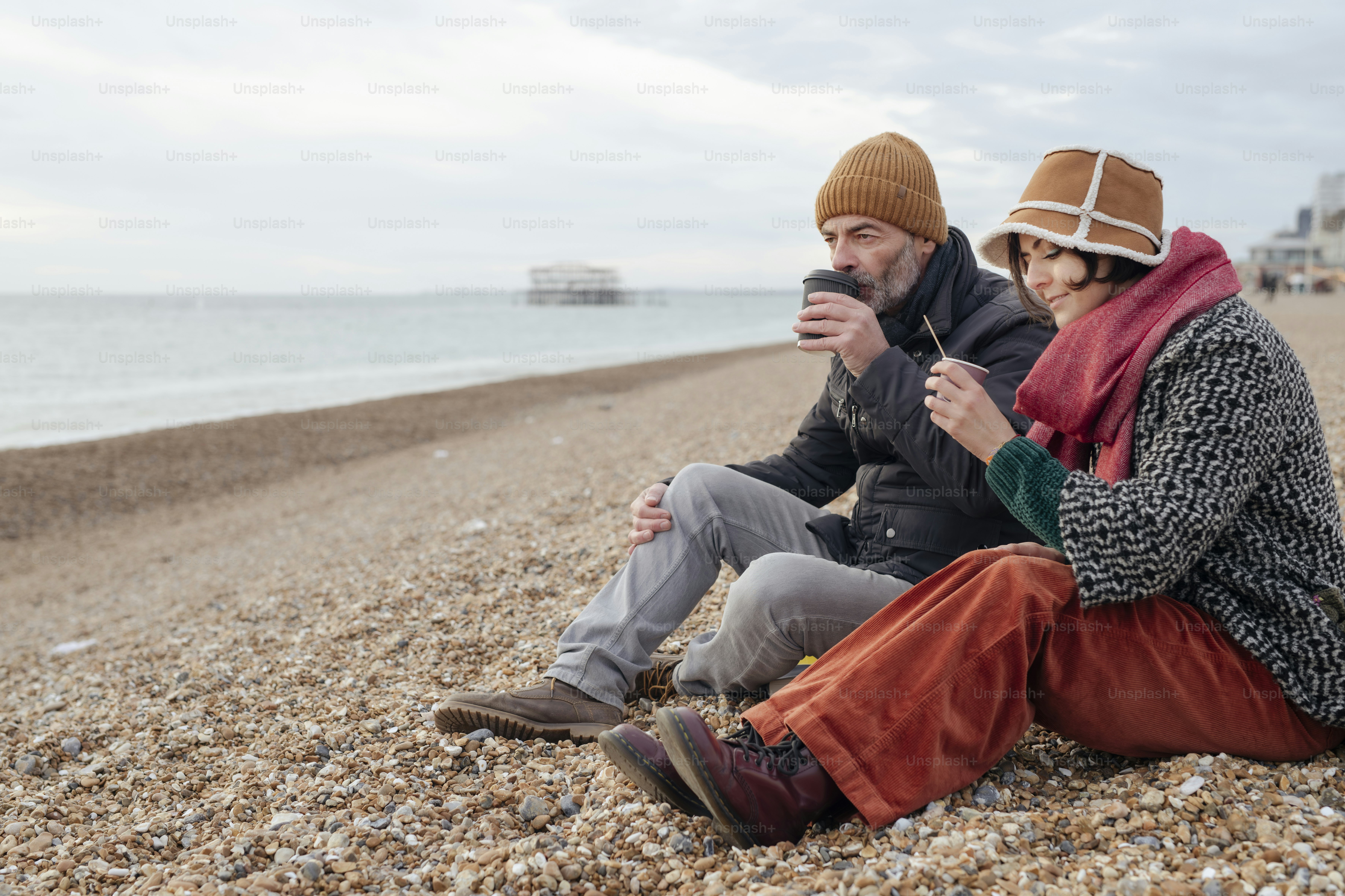 Un par de personas sentadas en lo alto de una playa