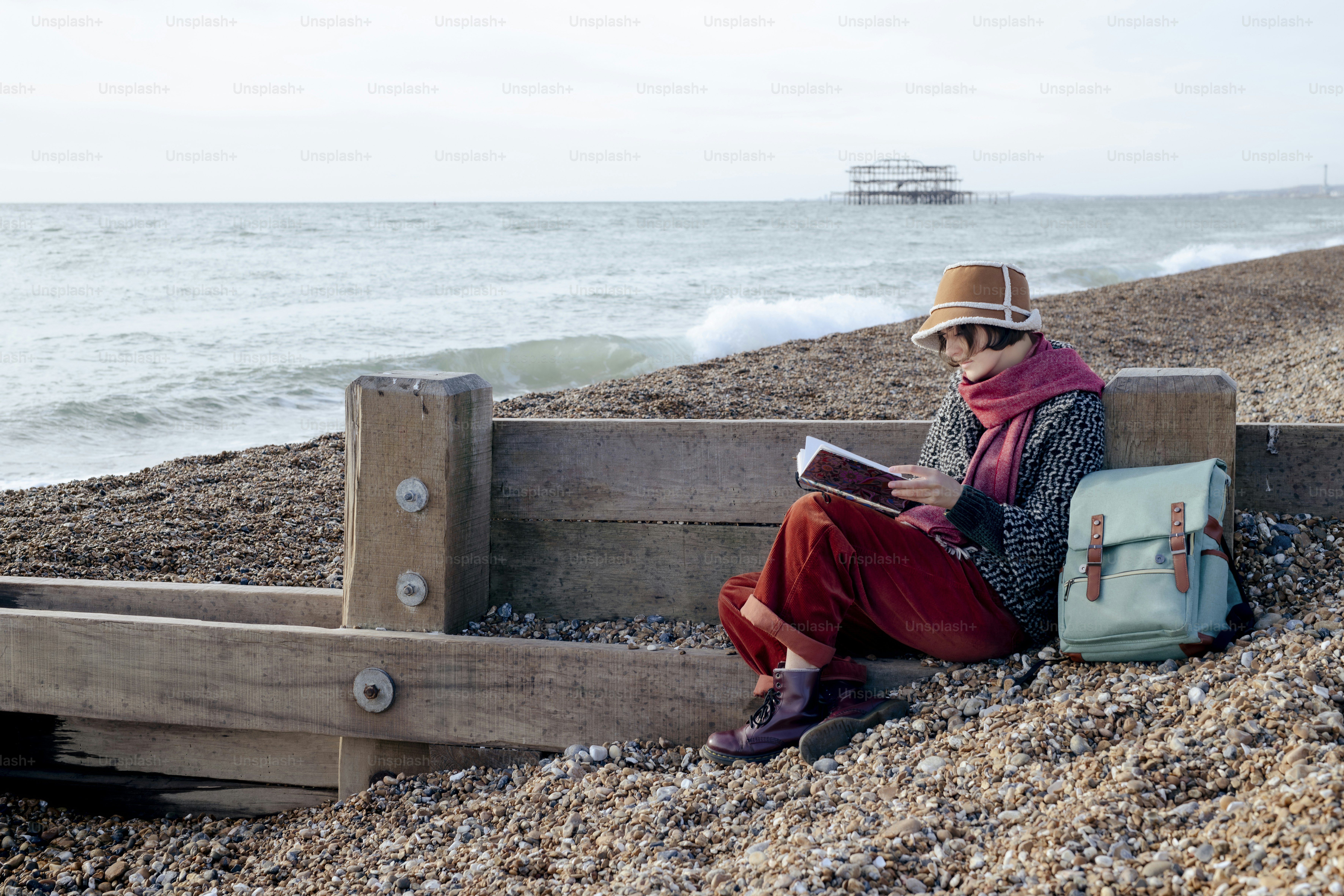 Una mujer sentada en un banco leyendo un libro