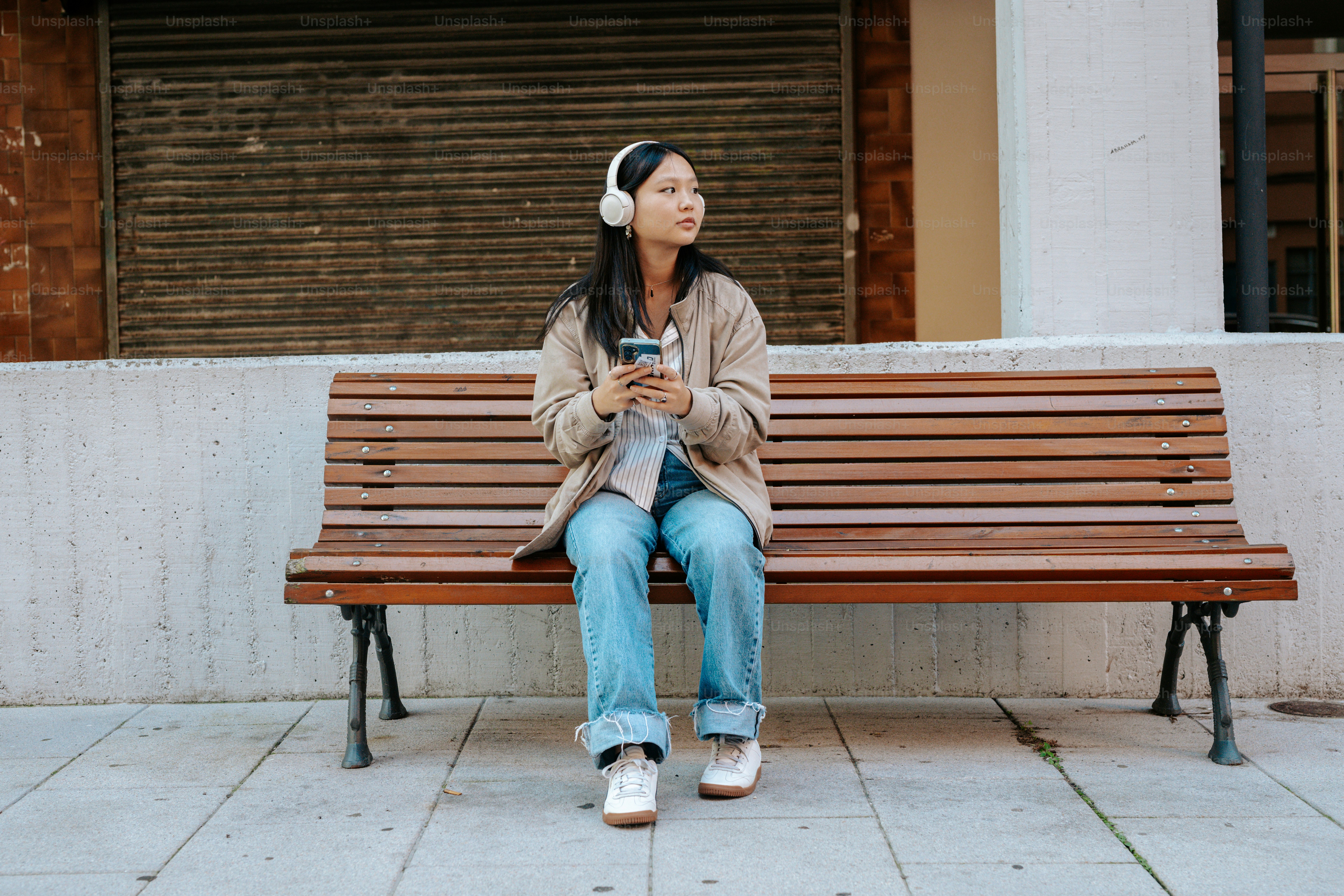A woman sitting on a bench using a cell phone