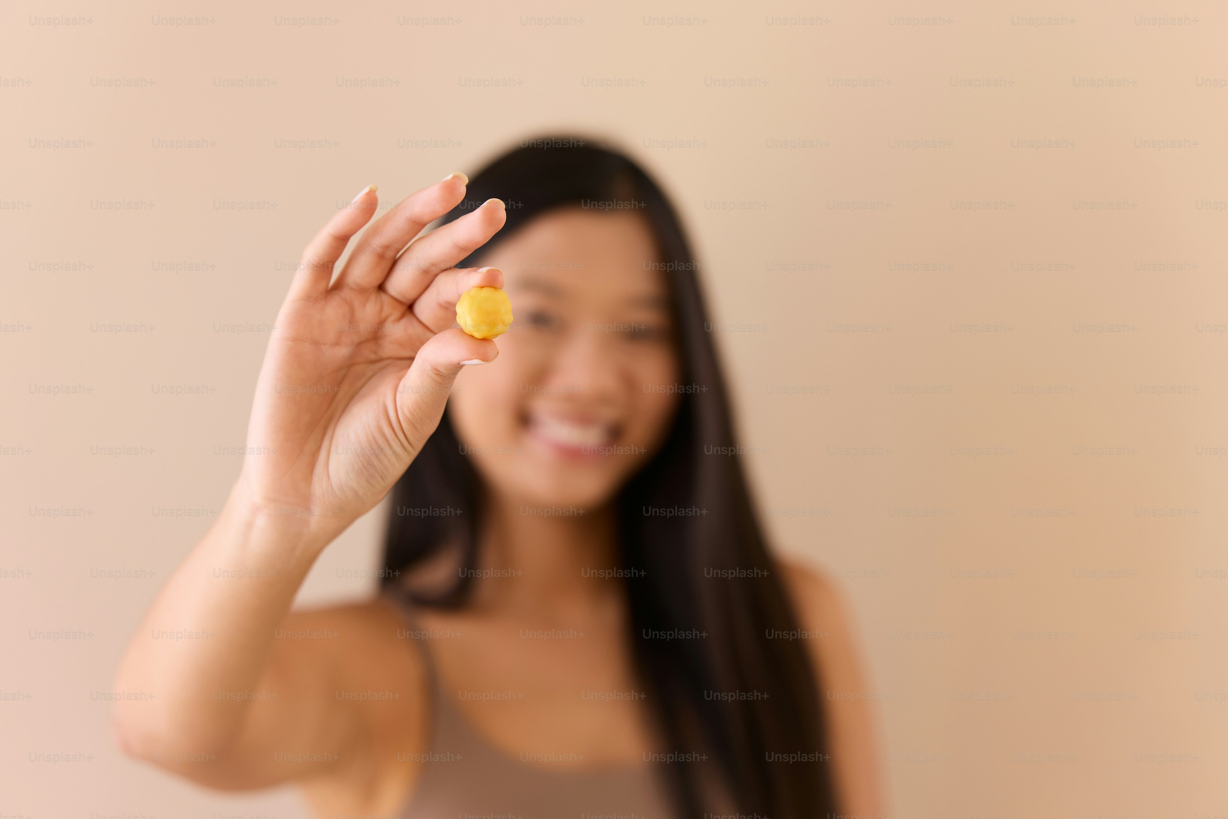 Une femme tenant un fruit devant son visage