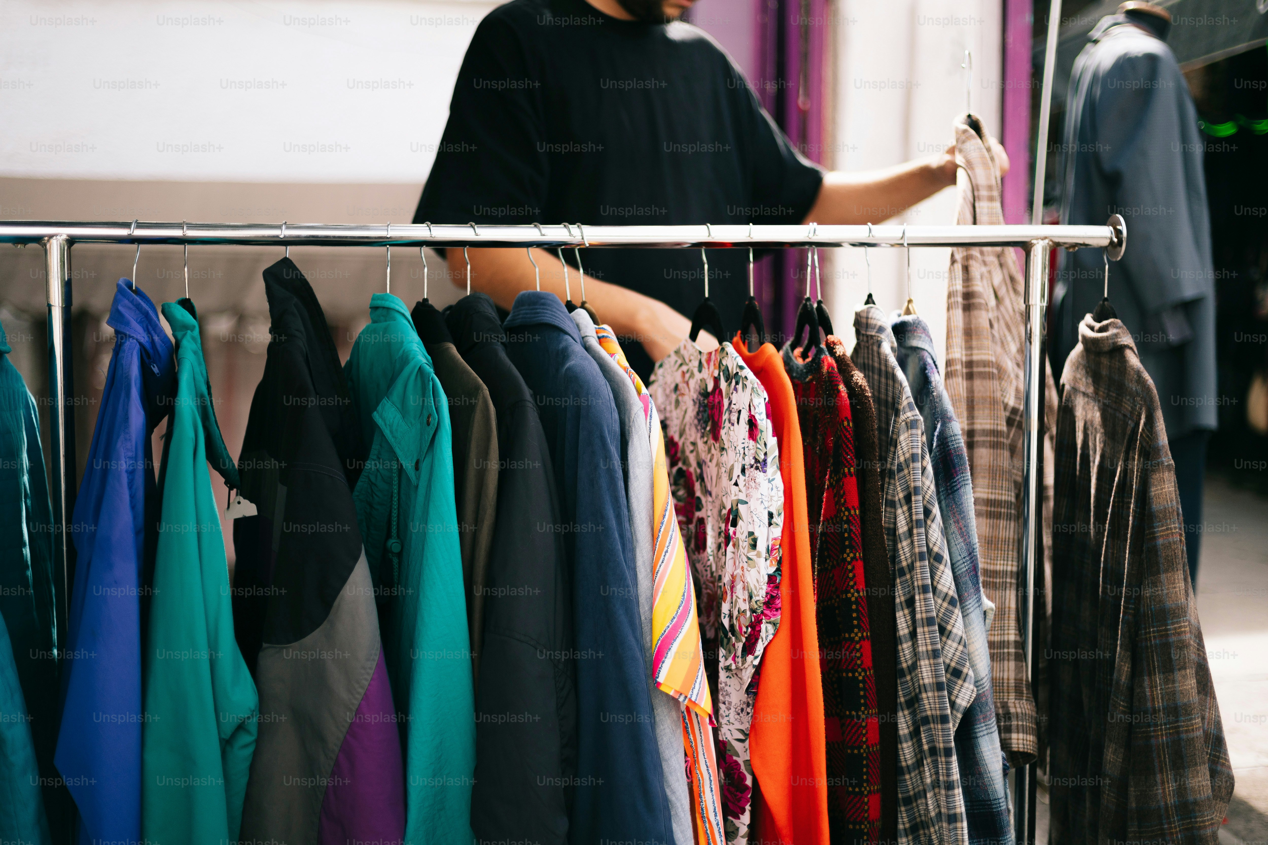 A man standing in front of a rack of clothes