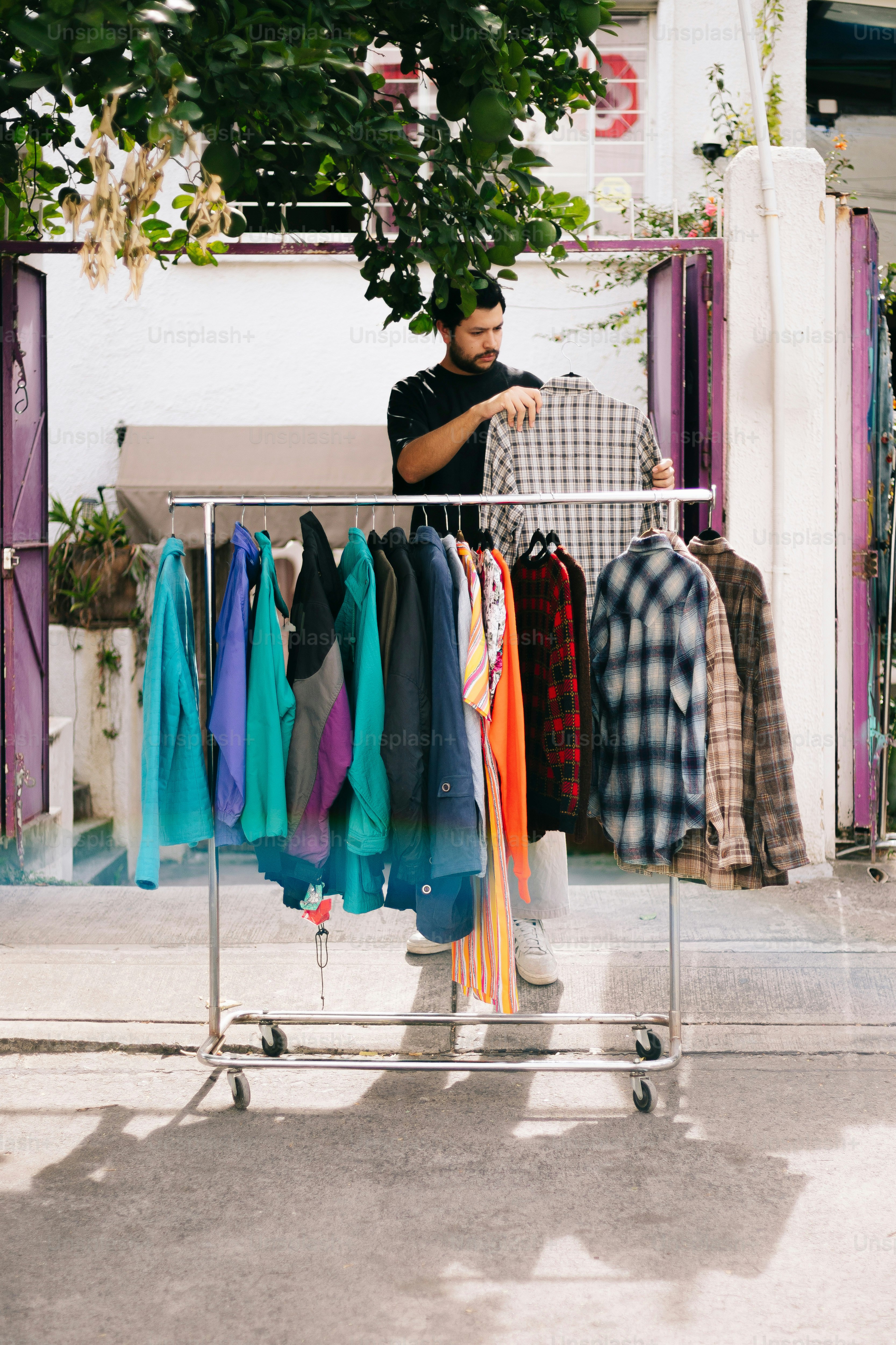 A man standing in front of a rack of shirts