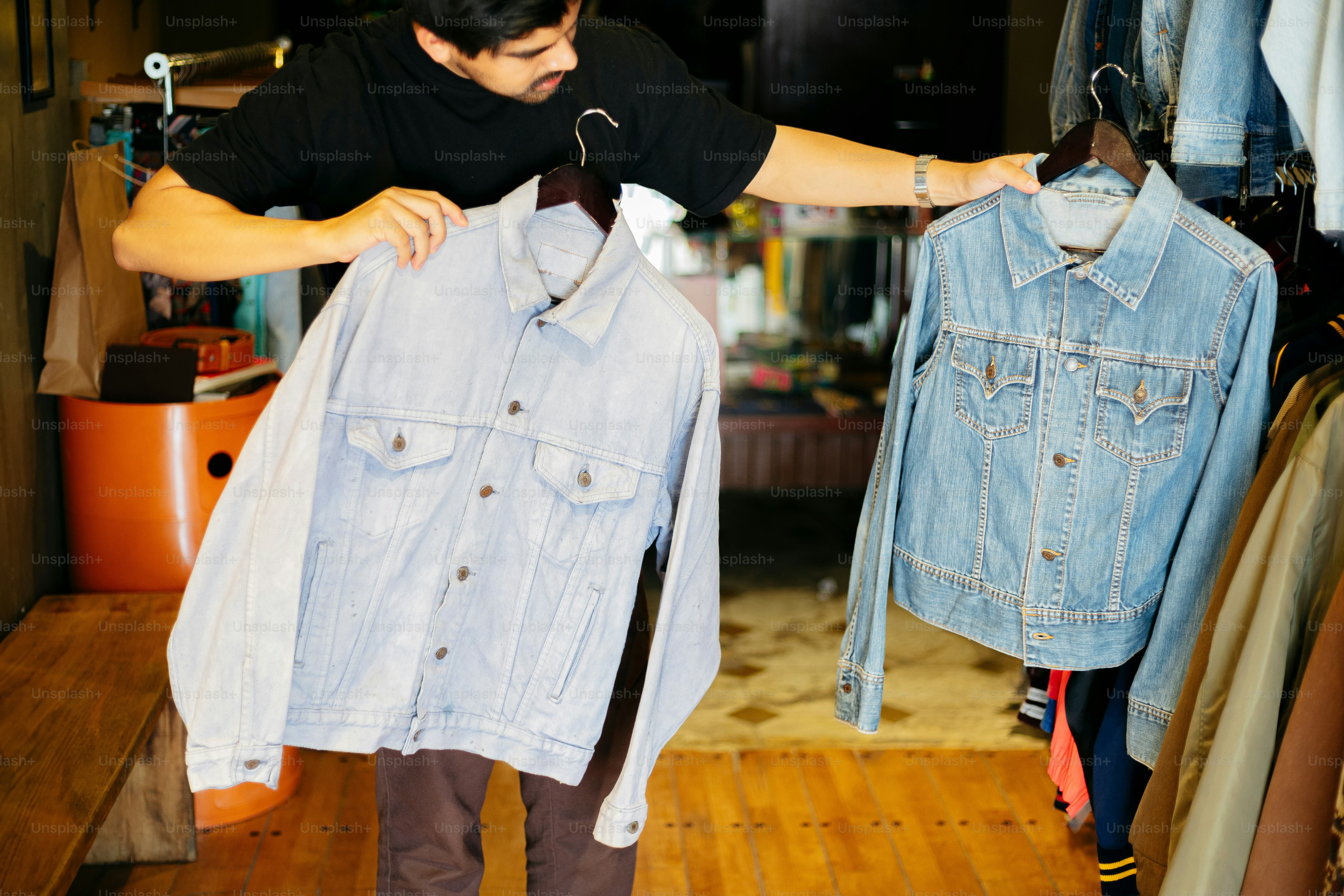 A man is trying to find a denim jacket