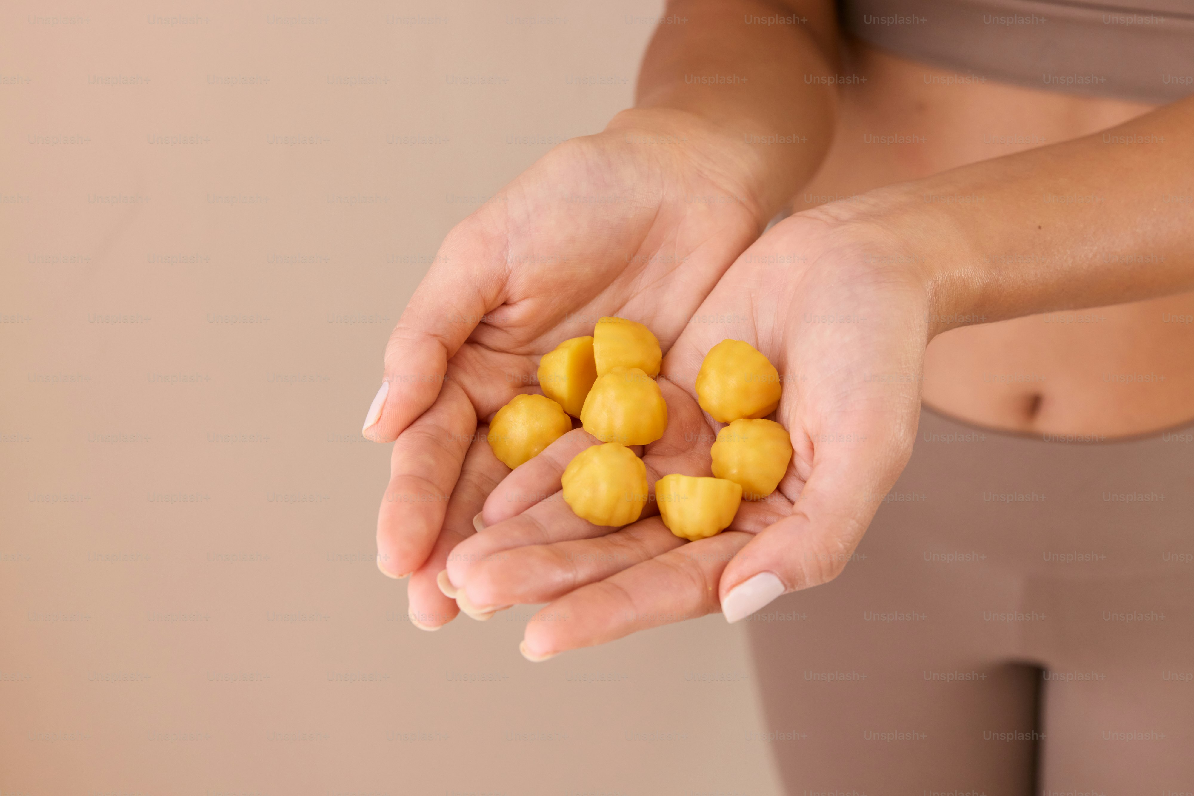 A woman holding a handful of yellow balls in her hands