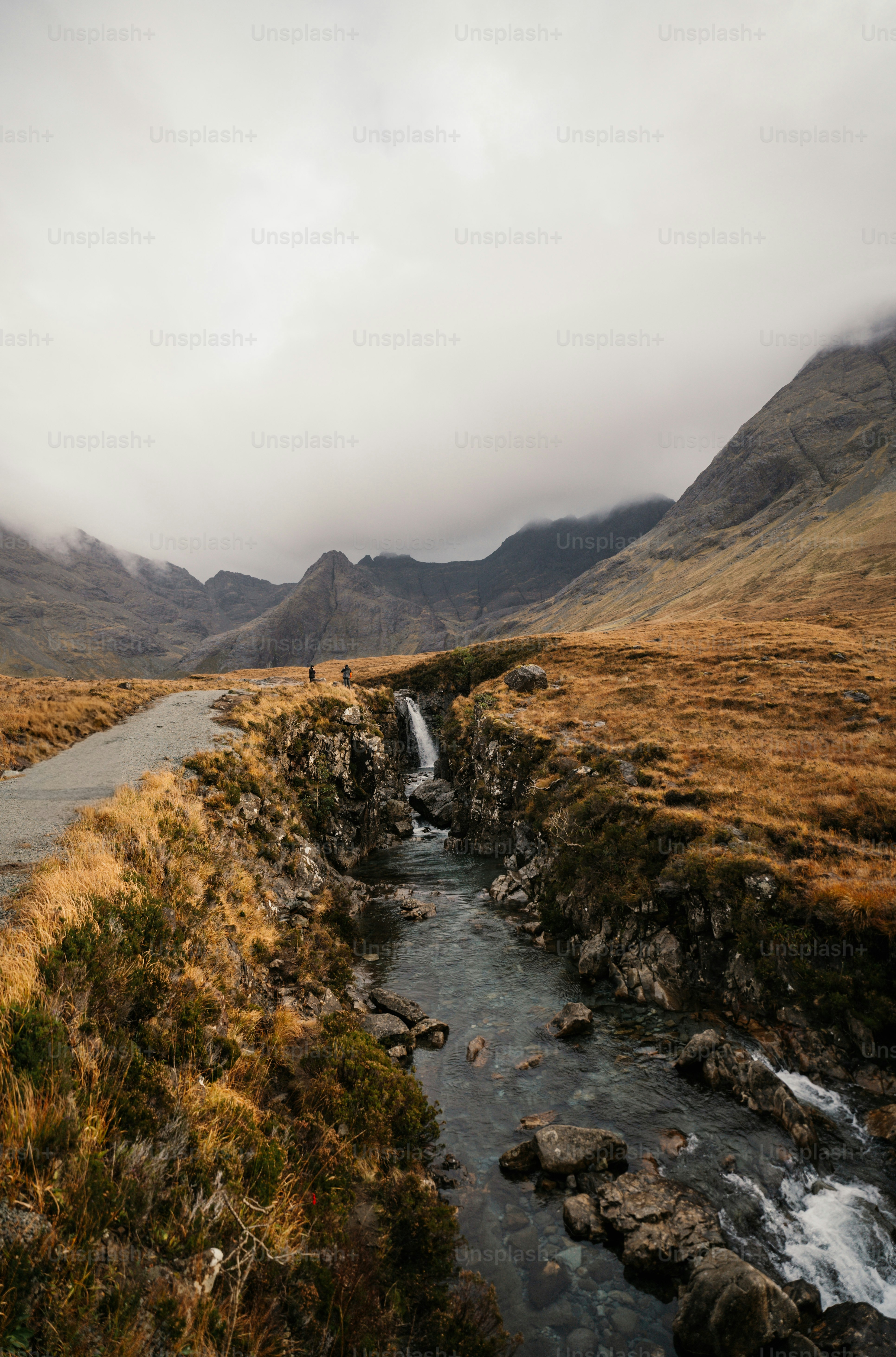 A stream running through a lush green valley