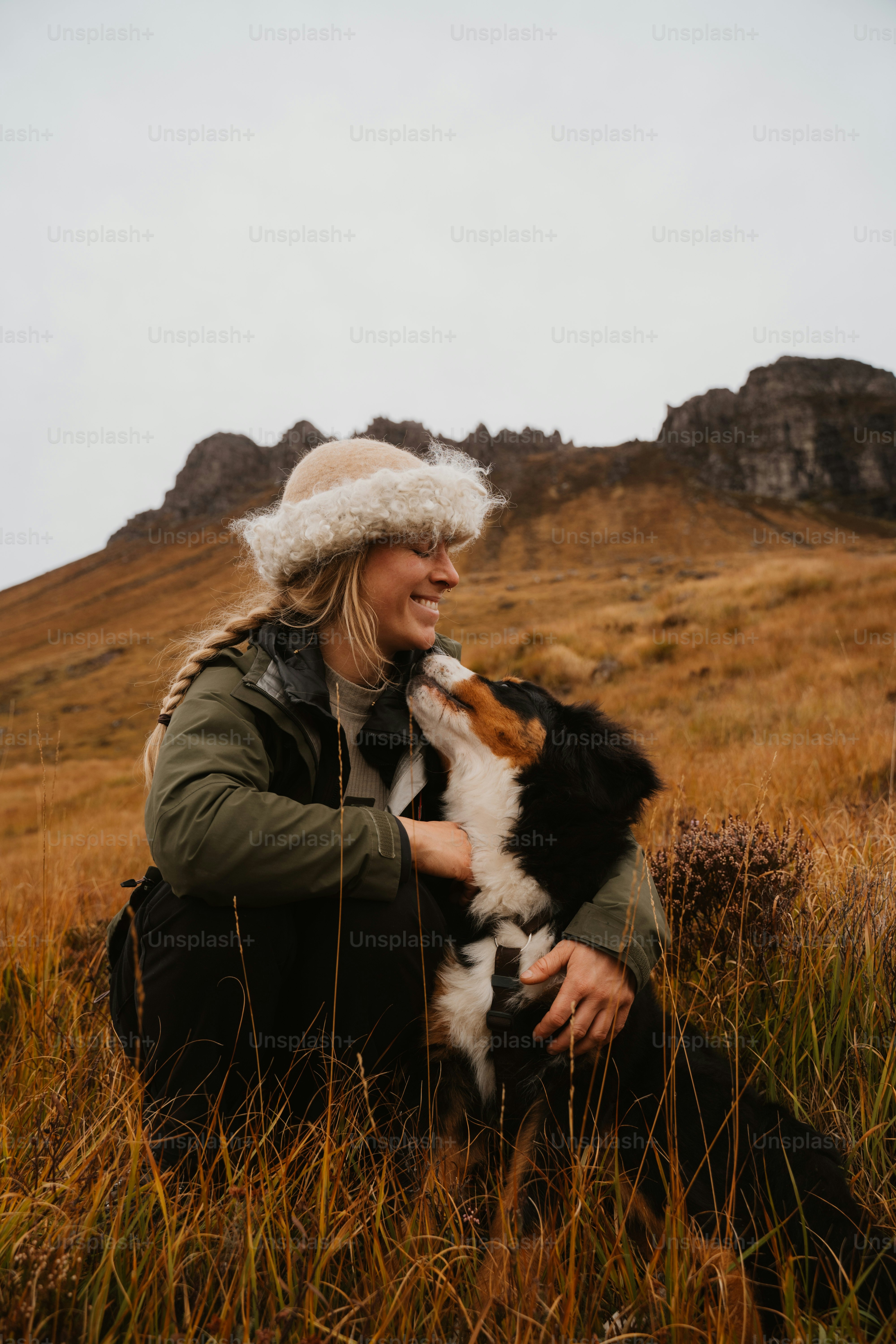 A woman sitting in a field with a dog