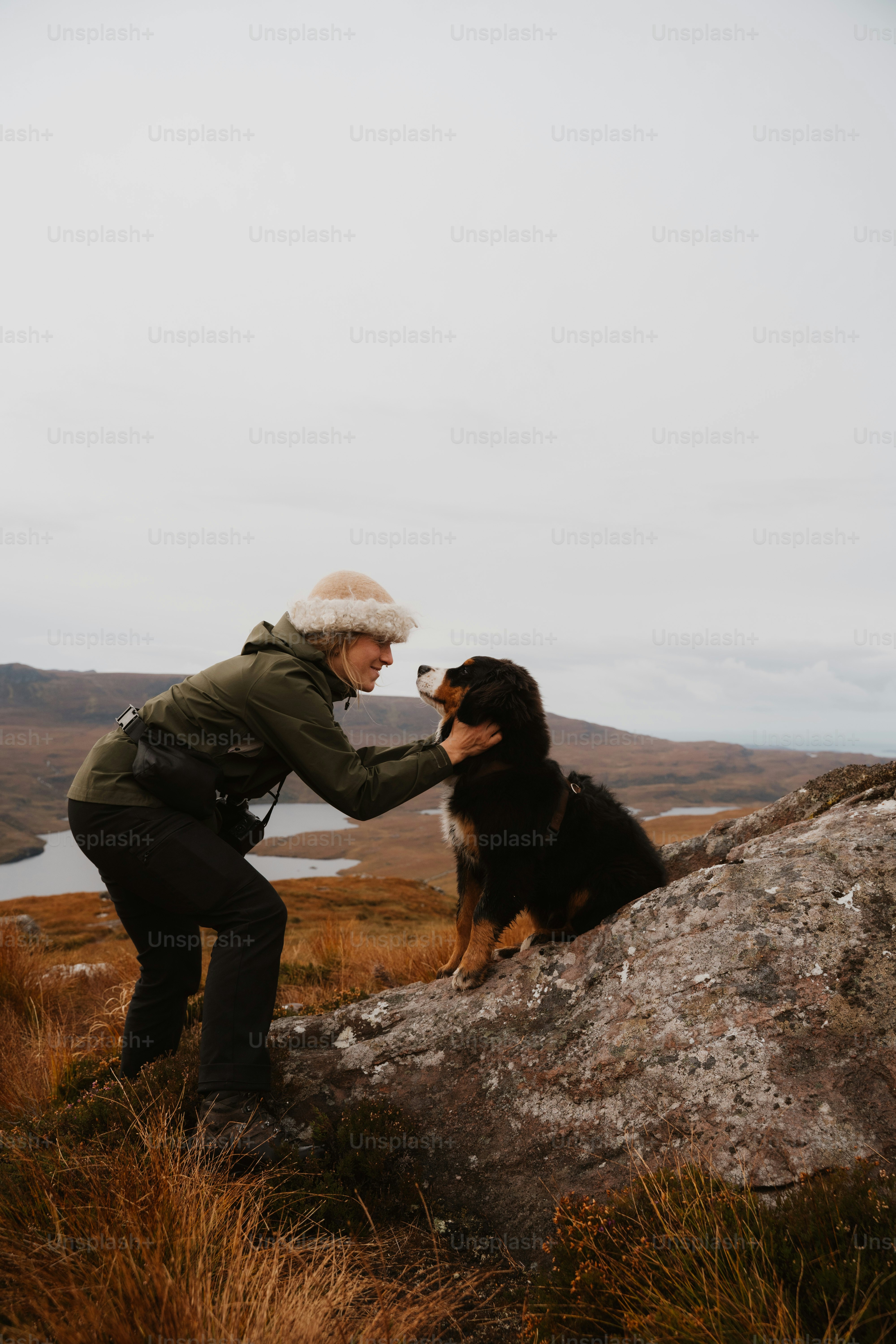 A woman and a dog on a mountain top
