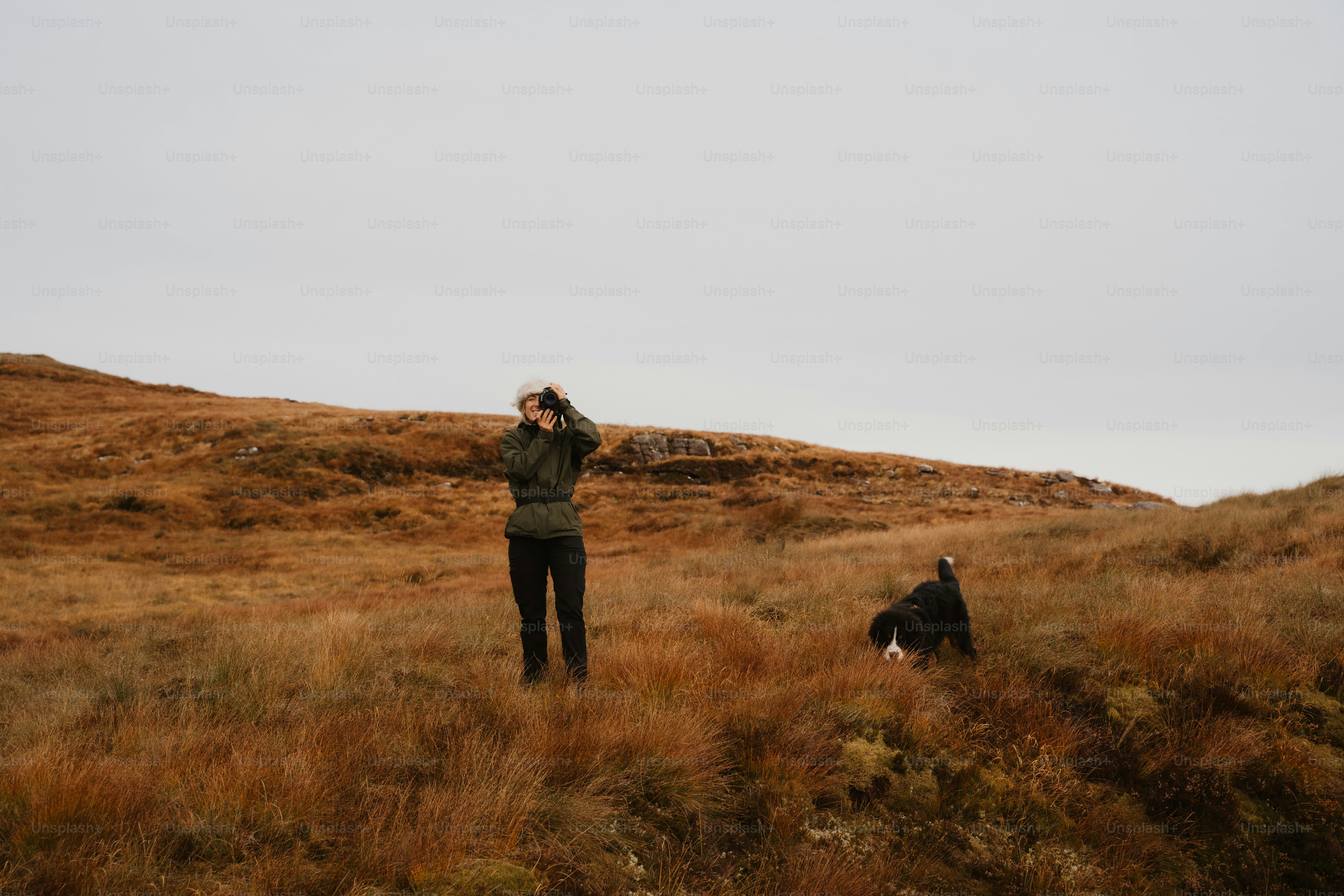 A person standing in a field with a dog