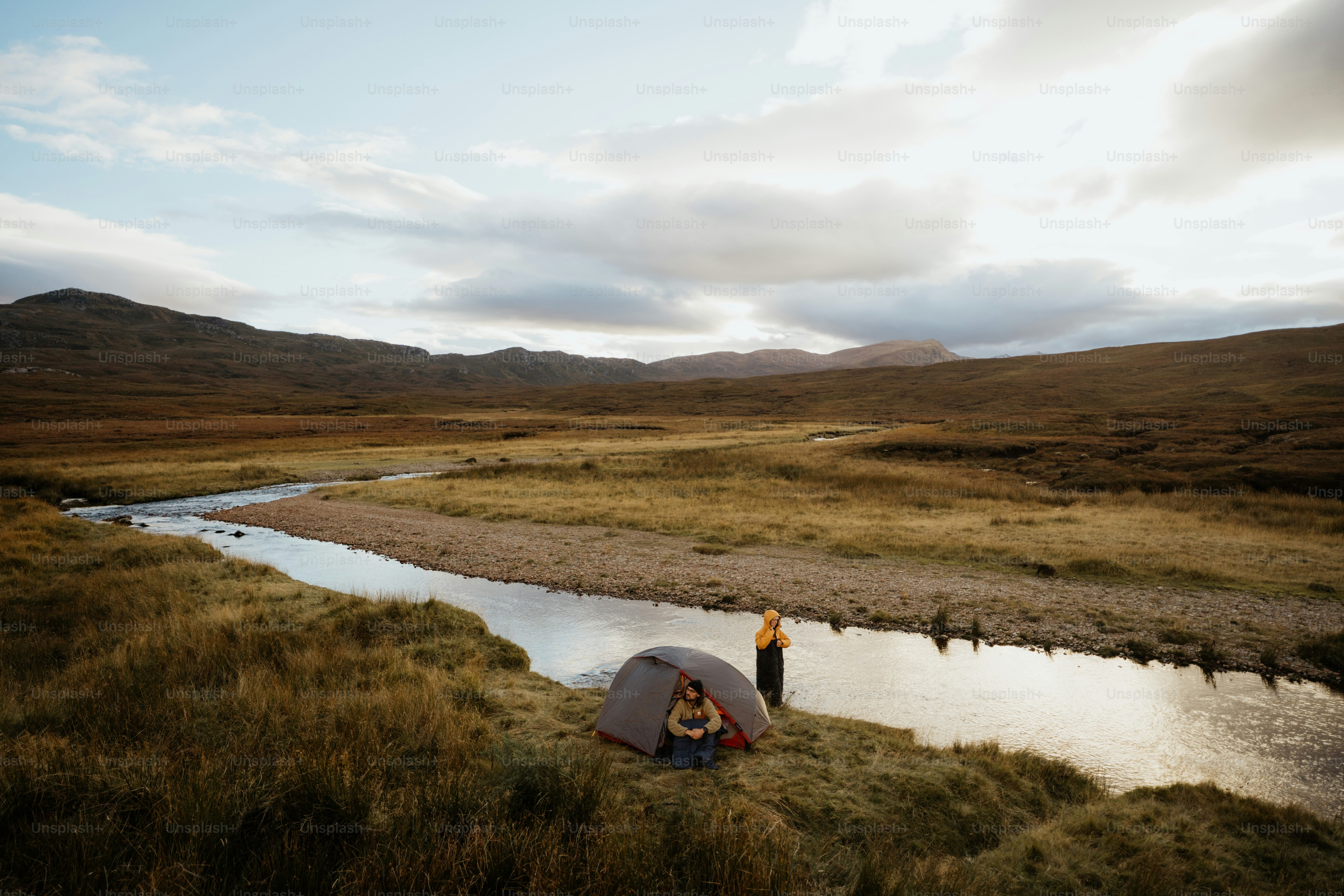 A man standing next to a tent in a field