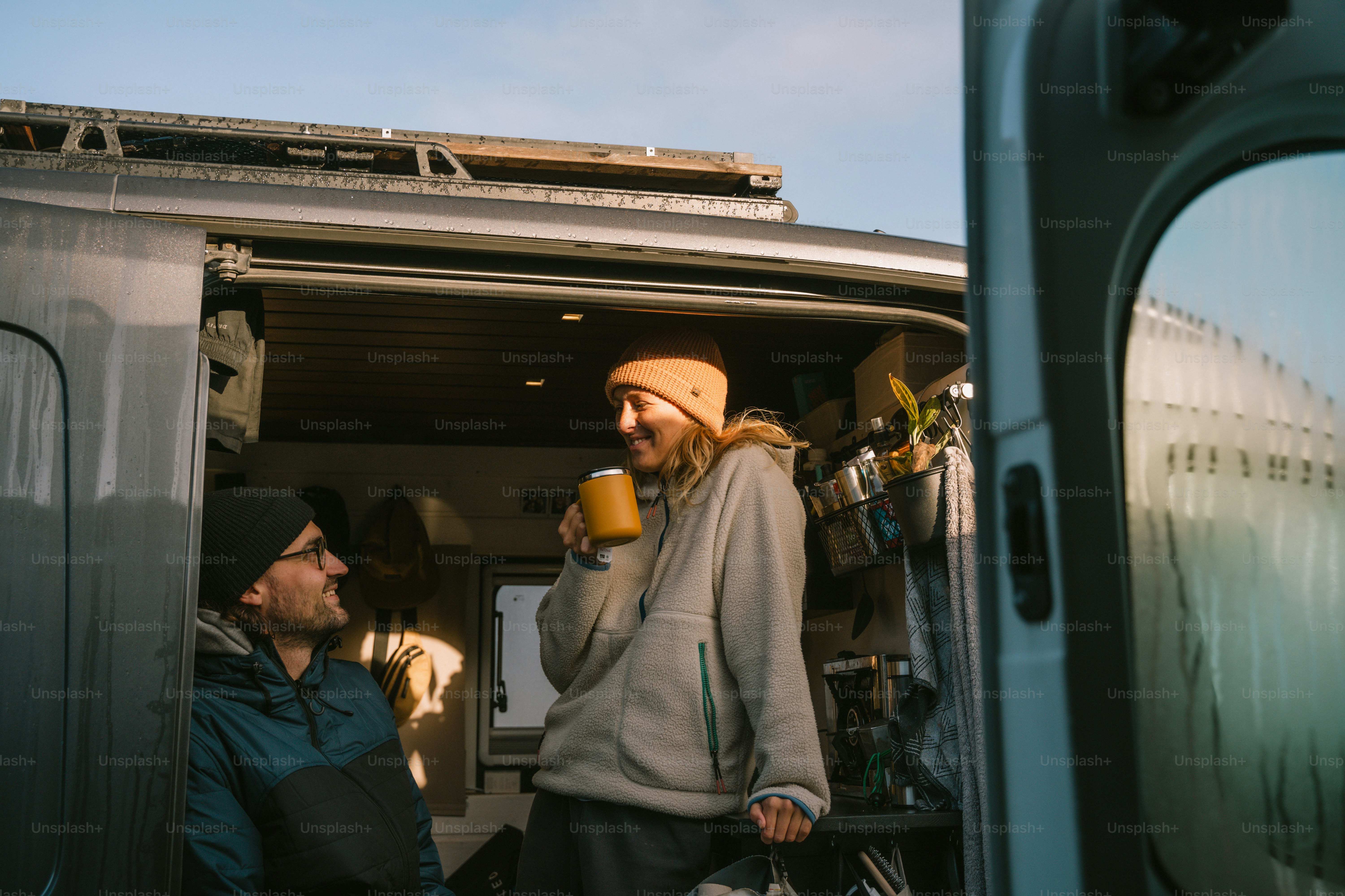 A couple of men standing in the back of a van