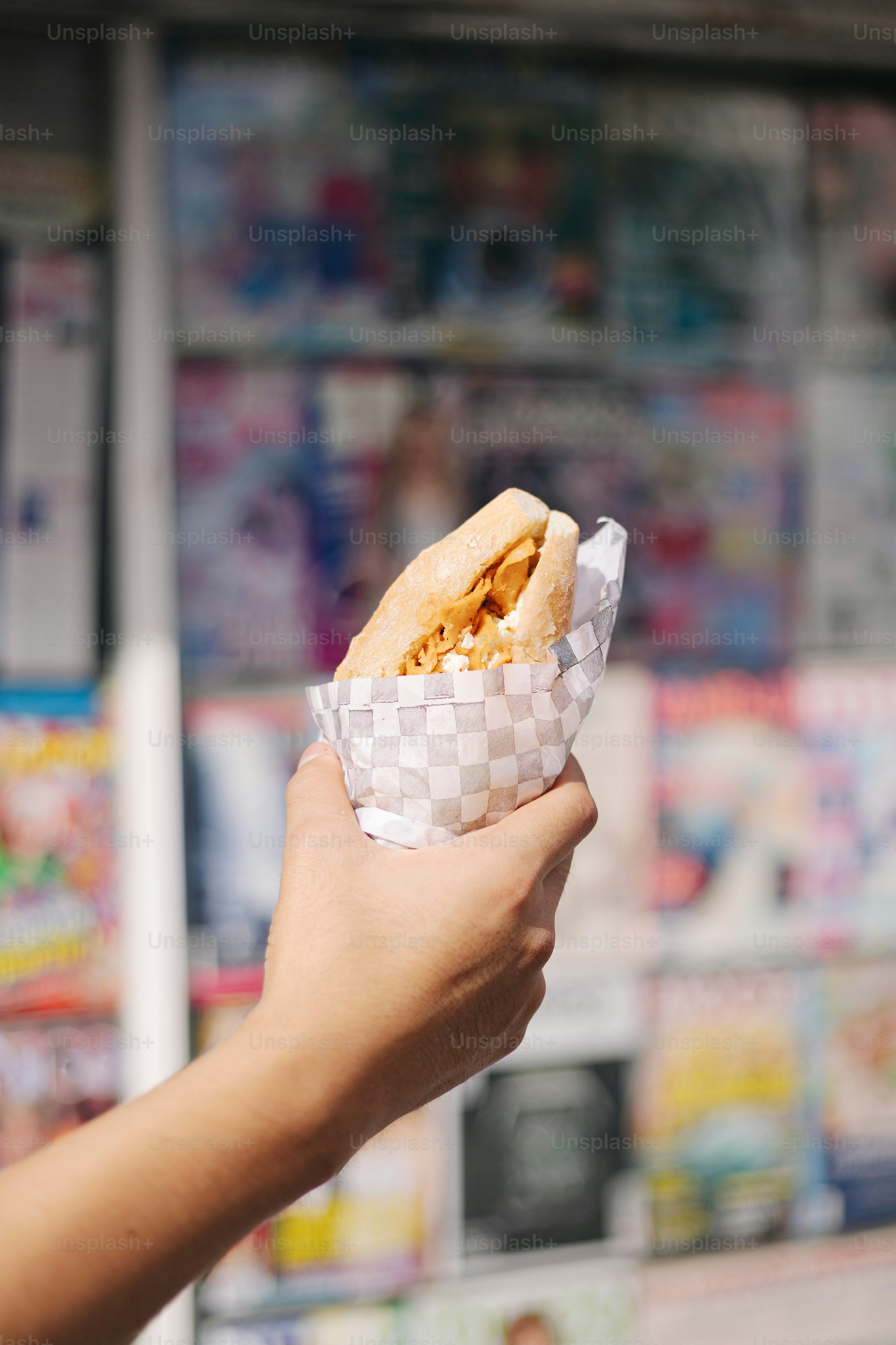 A person holding a hot dog in a wrapper